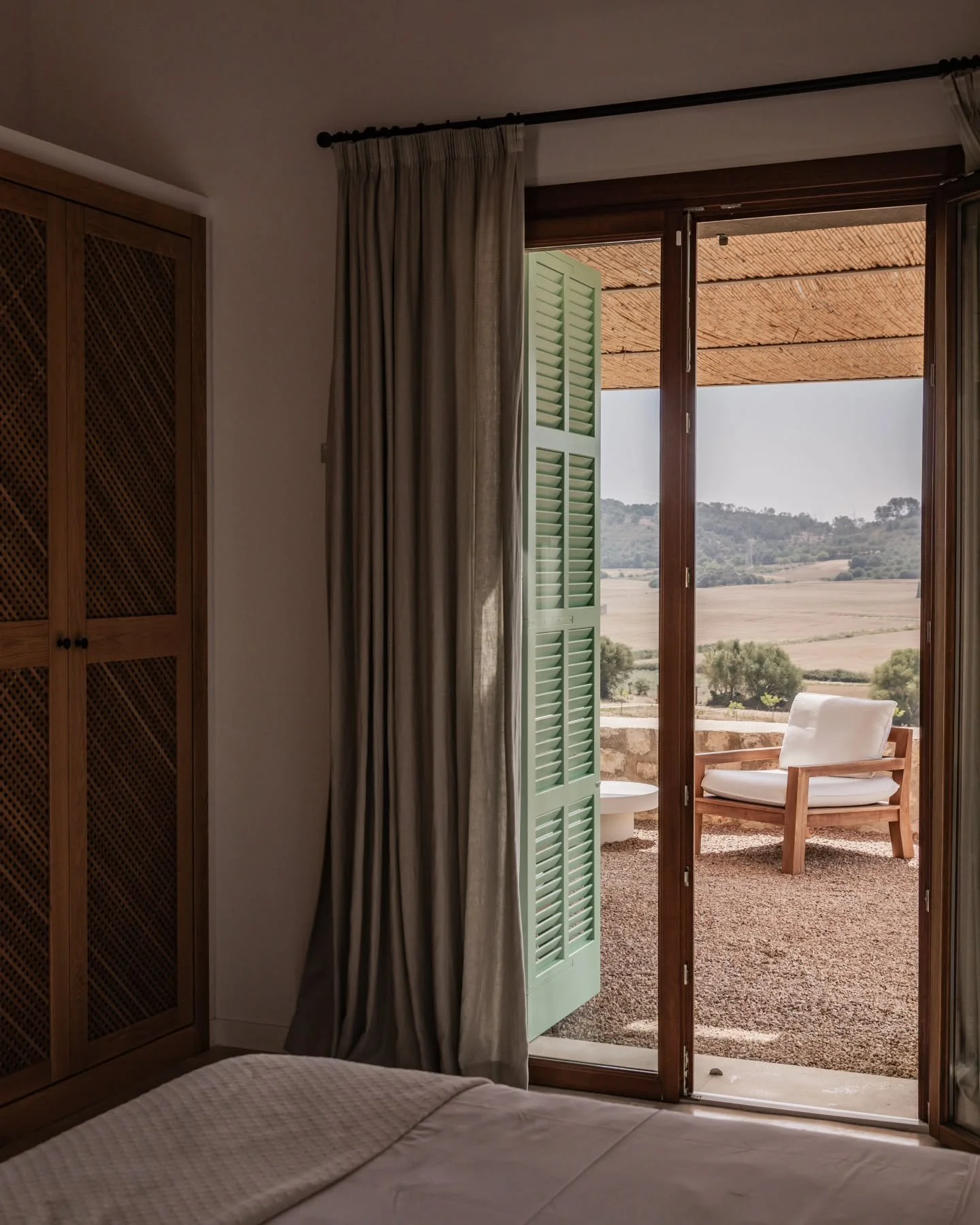 The light rests gently, 
filtered through olive branches 
and stone walls 
that have seen centuries pass. 

Inside, calm takes shape 
in textures of linen, 
the warmth of wood, 
and the silence of a room 
that seems to breathe with the land. 

Na Tos