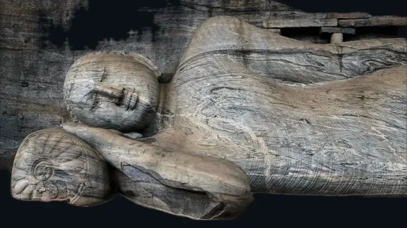 Questa fotografia scattata durante un viaggio culturale in Sri Lanka rappresenta la statua del Buddha reclinato, situata nel complesso di Gal Vihara a Polonnaruwa. La posizione di questa statua rappresenta il Parinirvana