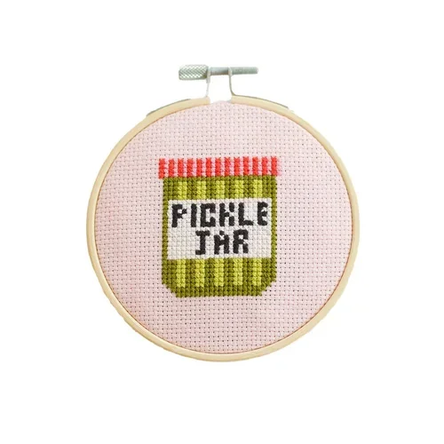 Cotton Clara Cross-stitch embroidery of a jar labelled "PICKLE JAR" in an embroidery hoop.