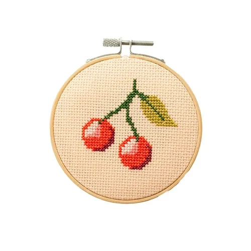 Cotton Clara Cross-stitched embroidery of two cherries with green stems and a yellow leaf in a wooden hoop