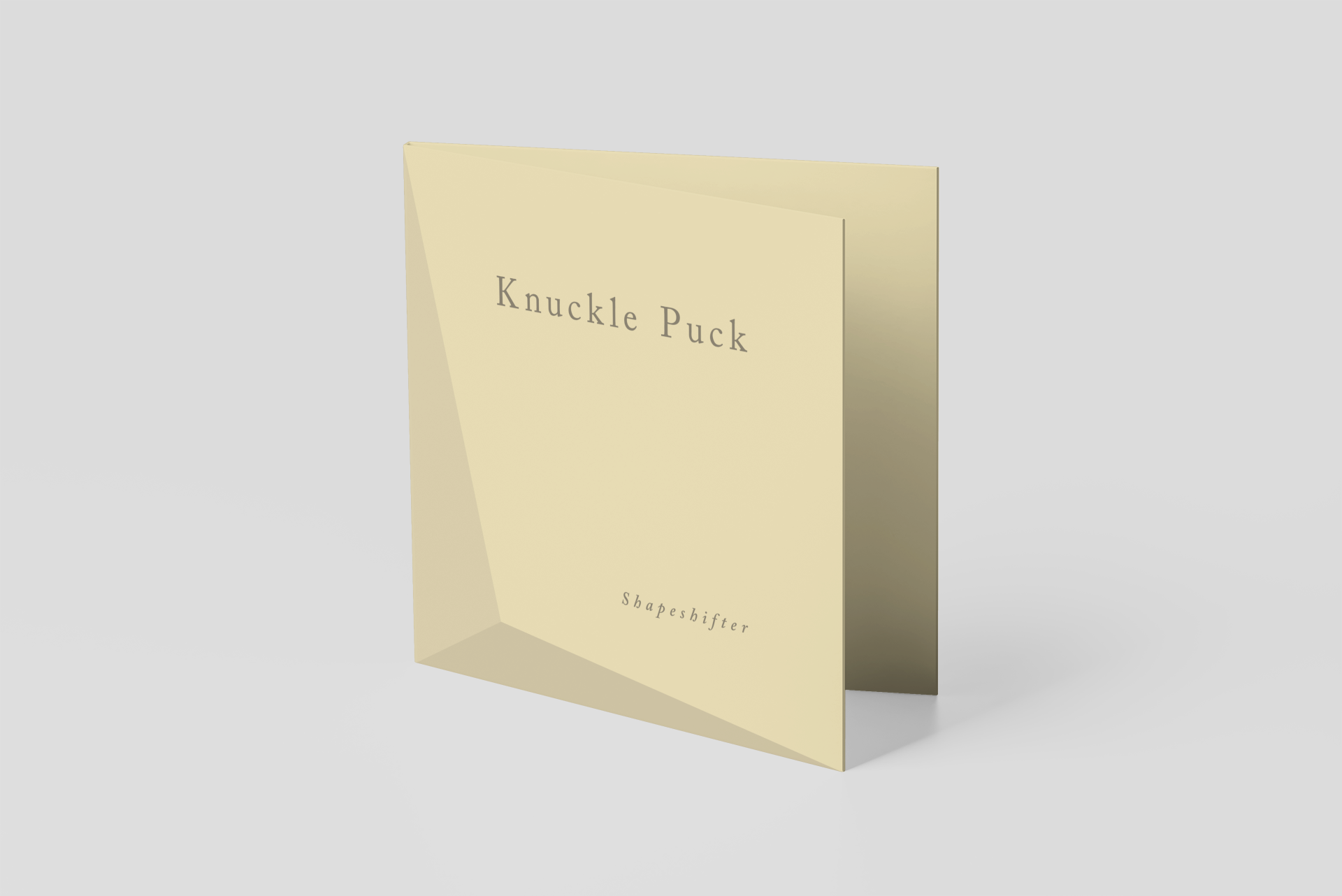 A folded beige greeting card with the text 'Knuckle Puck' in large font and 'Shapeshifter' in smaller font printed on the front.