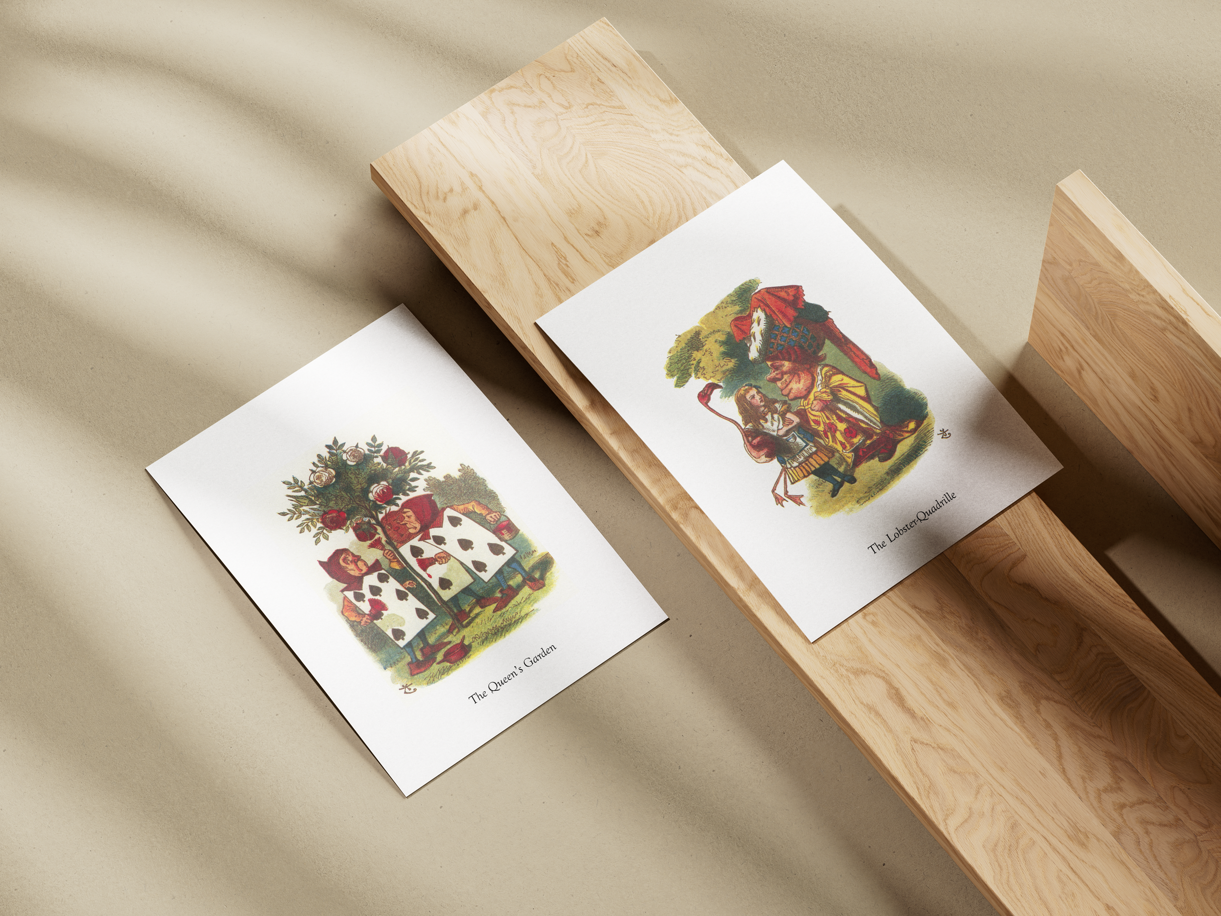 Two playing cards, the Queen's Garden and The Lobster Quadrille, laid on a wooden surface with shadows in the background.