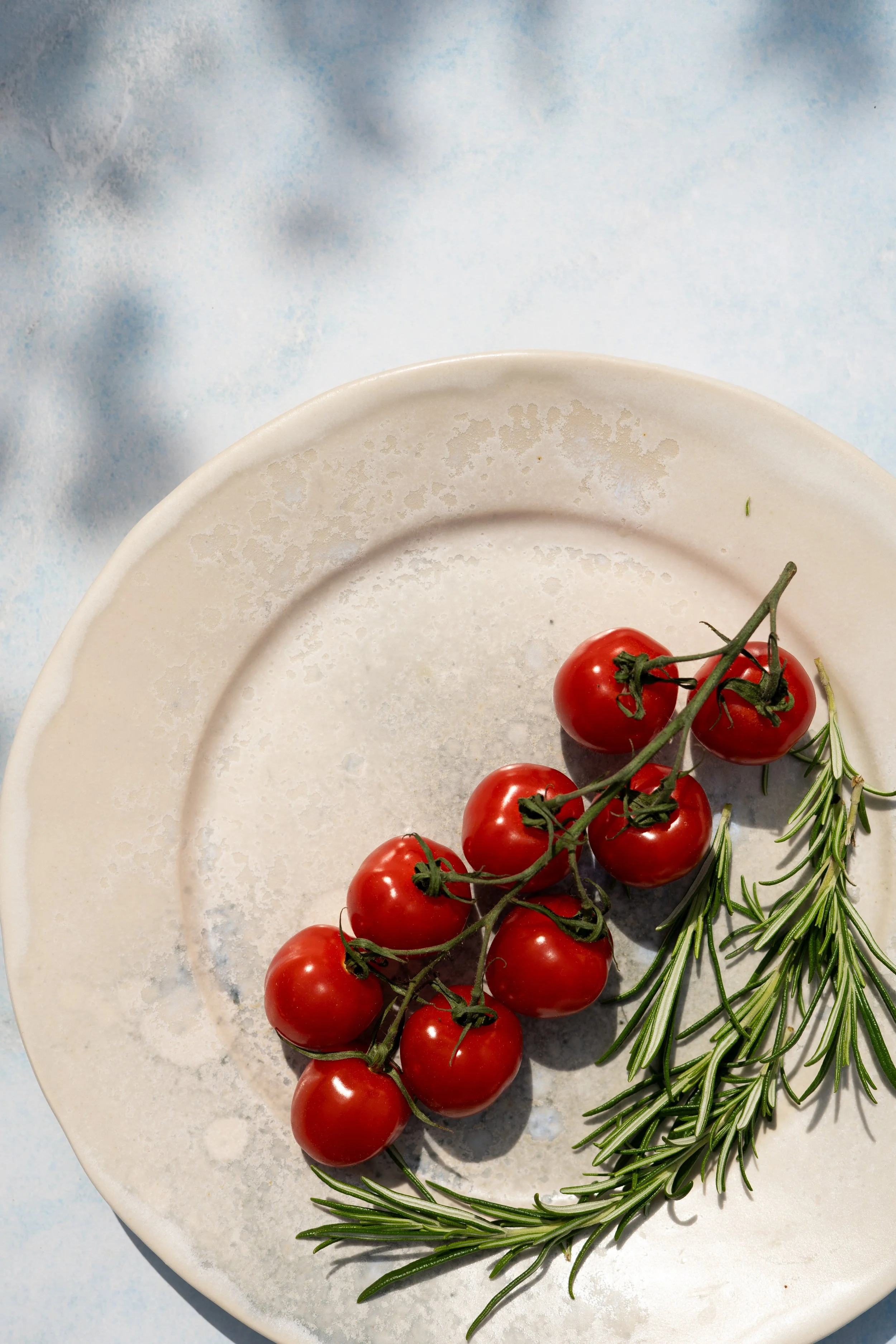 tomatoes in the sun on a fermoyle pottery plate. Photography and styling by Loraine Cox Photography