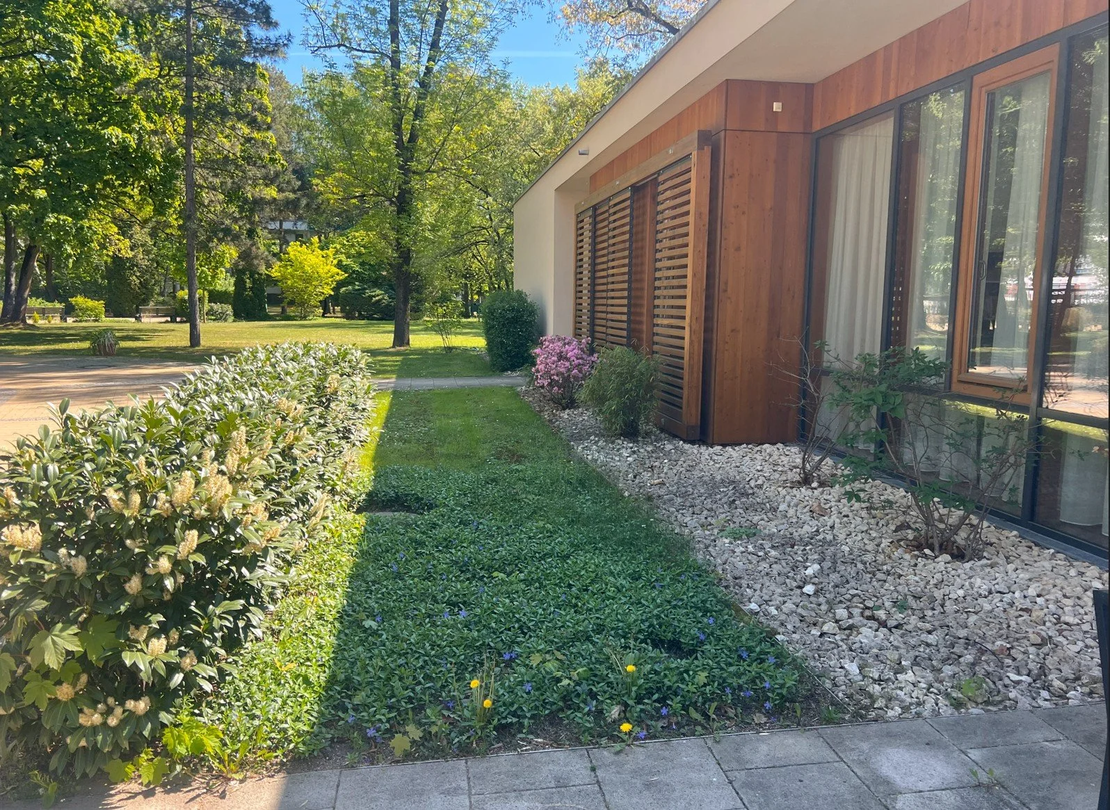 Nachhaltige Garten- und Freiraumgestaltung mit Kiesflächen, Rasen, Staudenpflanzen und Heckenstruktur