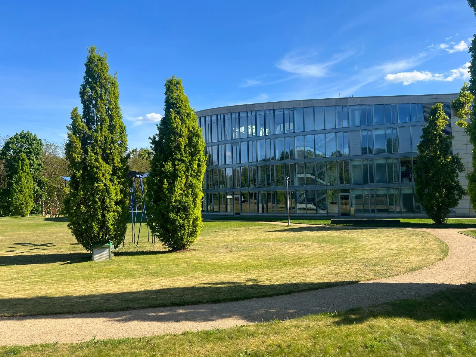 Freianlage mit geschwungenem Weg und altem Baumbestand