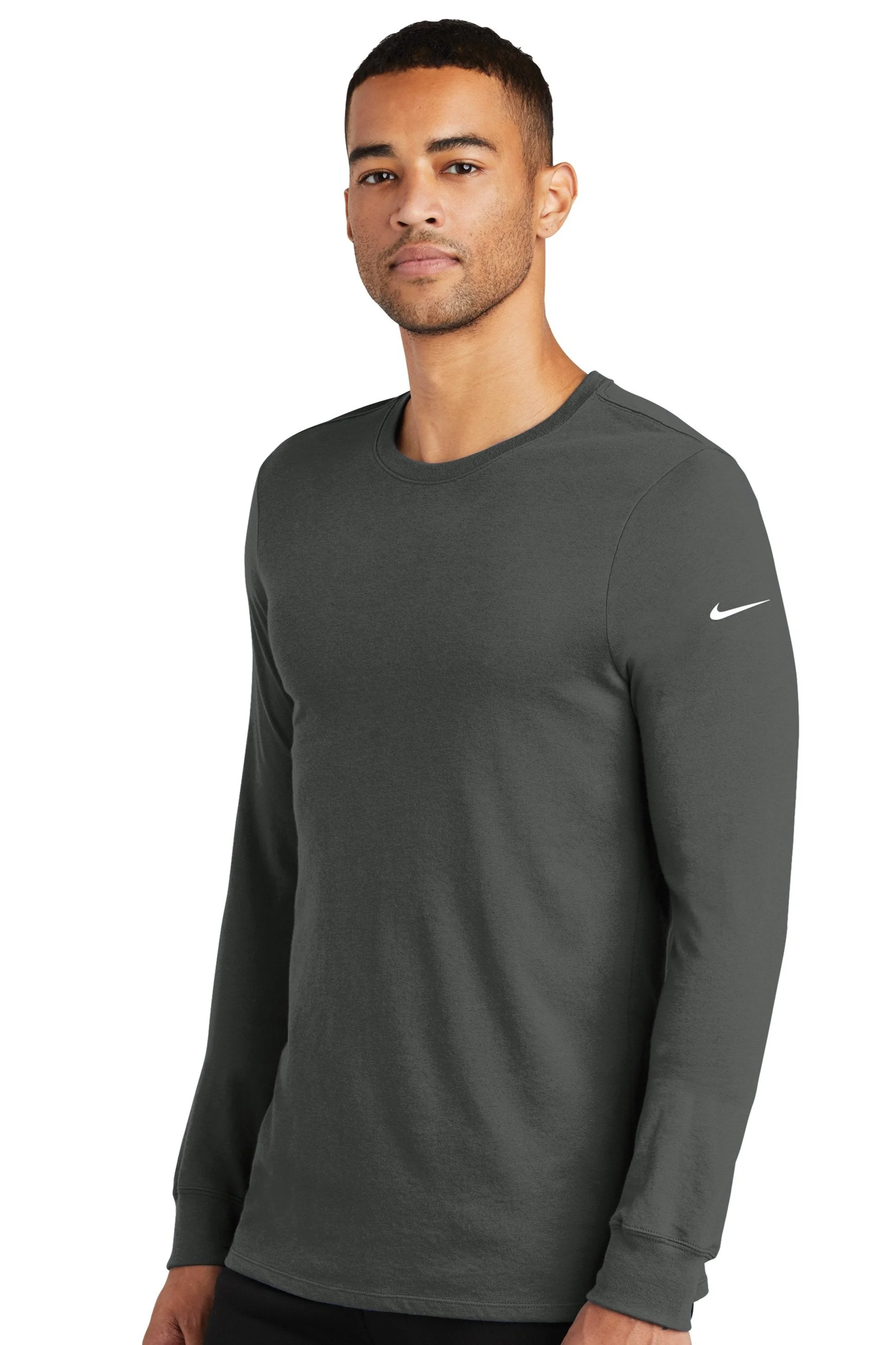 Man in dark gray Nike long-sleeve athletic shirt standing against white background.