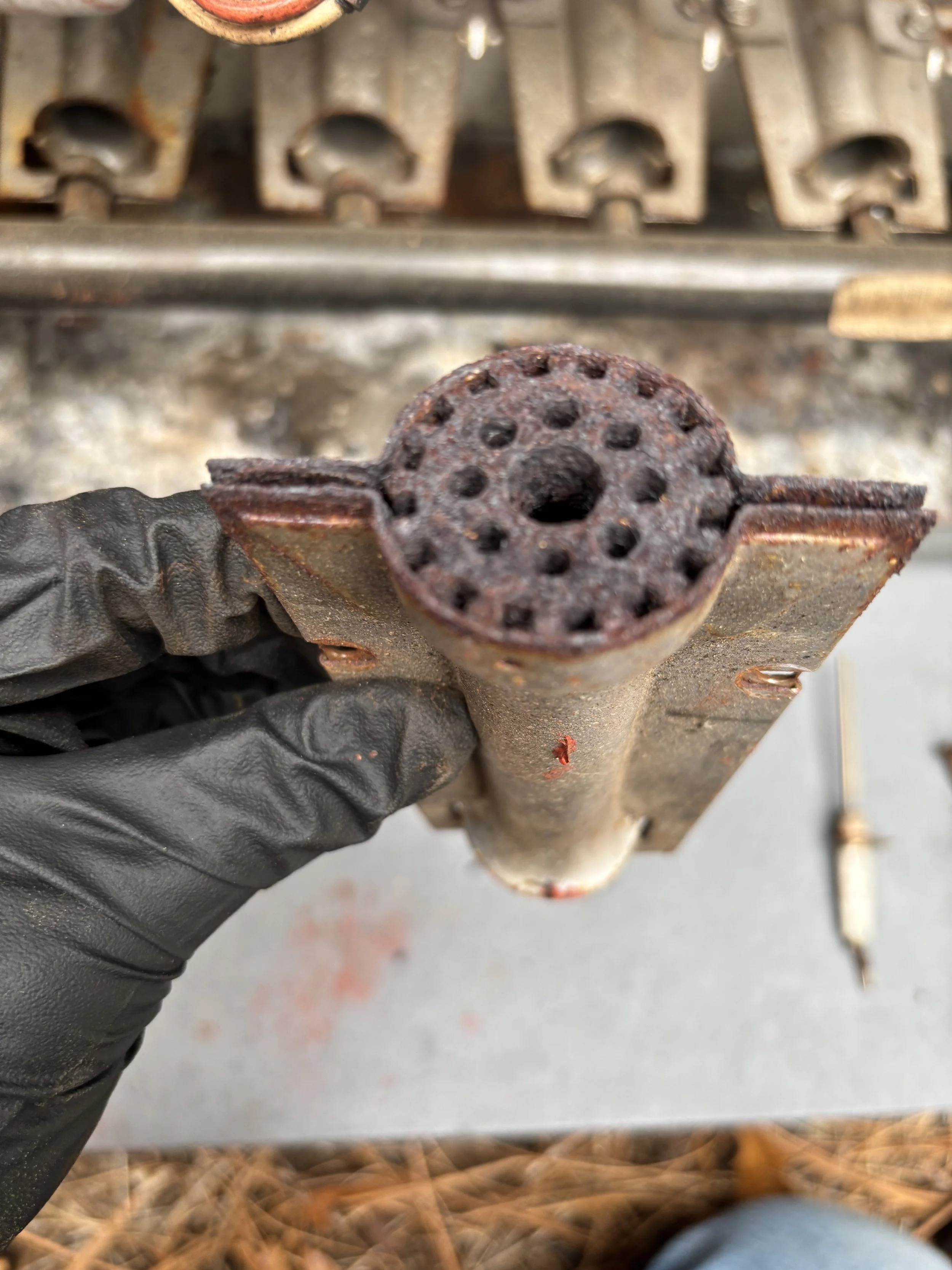 Furnace repair being performed on a rusty burner