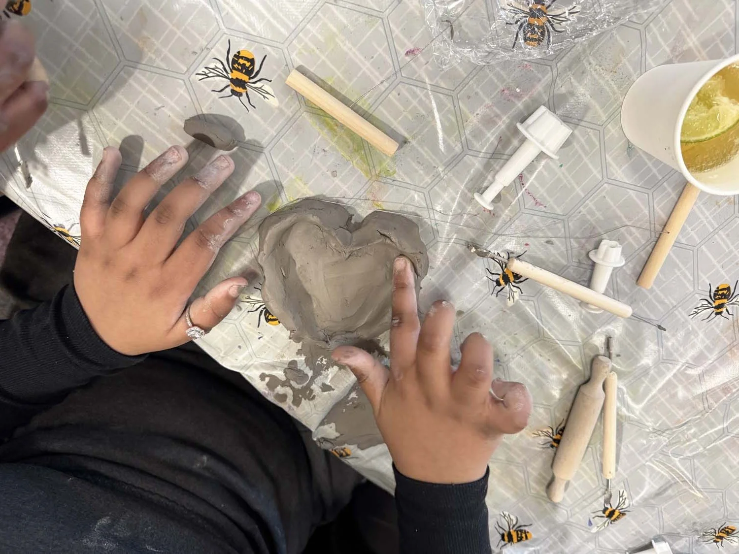 A close up of a child’s hands, sculpting a clay heart whilst learning about the concept of Meta Sculpture during the Conscious Sculpture Art Club