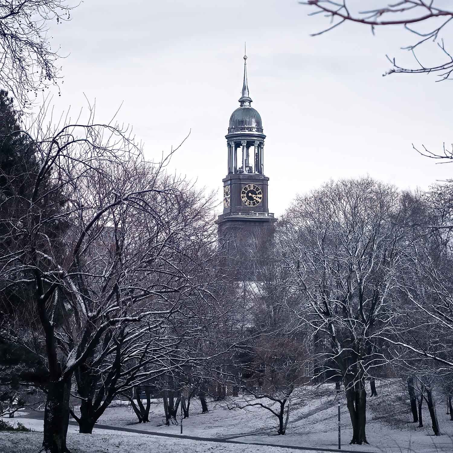 A clock tower surrounded by snow-covered trees in a winter scene.