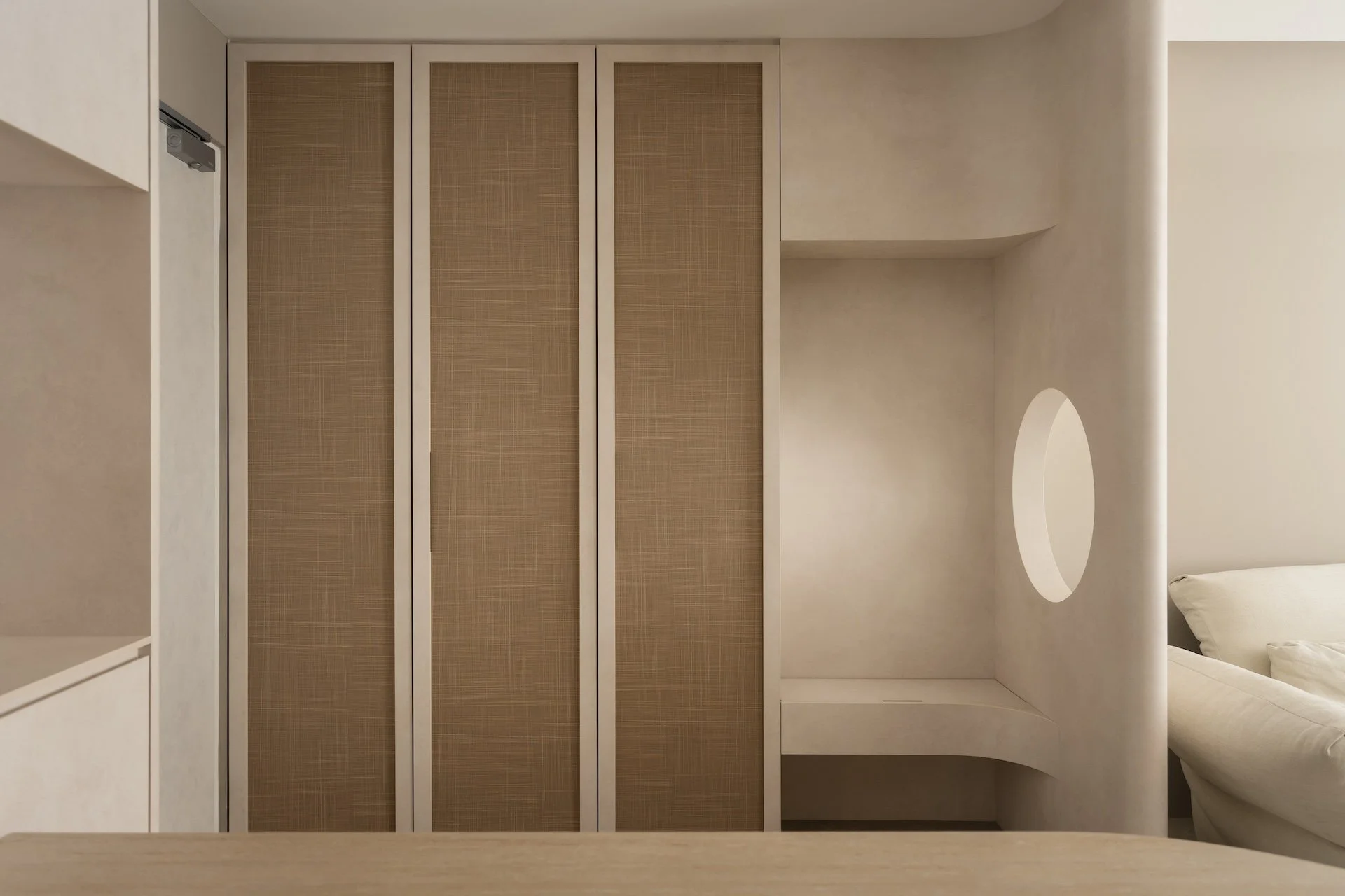 A modern bedroom with built-in cabinetry featuring mesh panel doors, a curved alcove with a circular mirror, and a white bed with pillows.