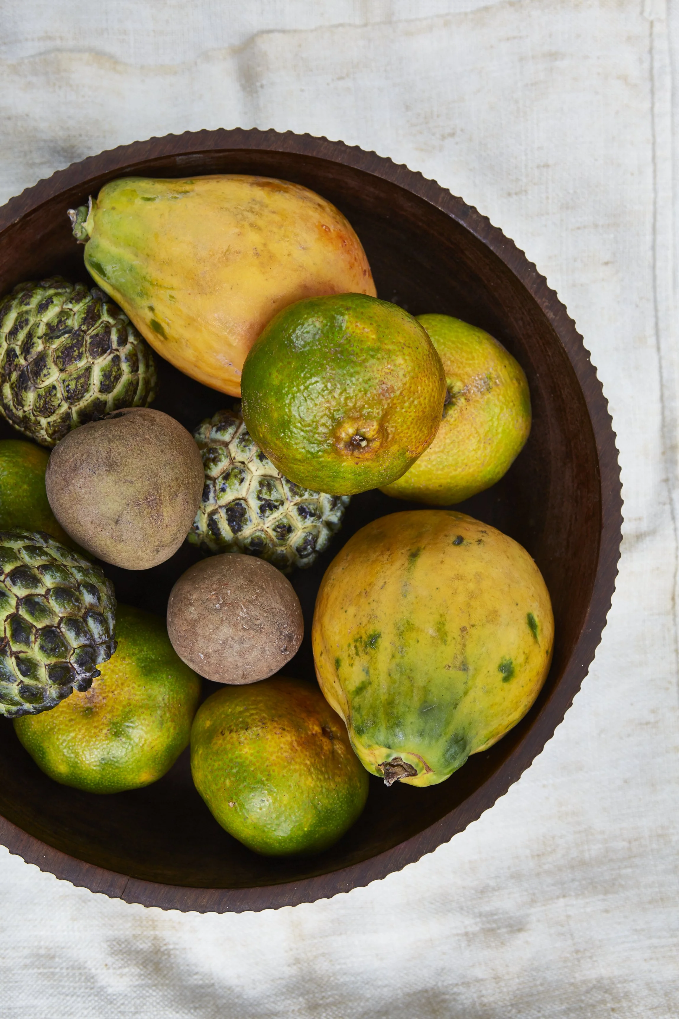 Various yellow and green fruit in a bowl.