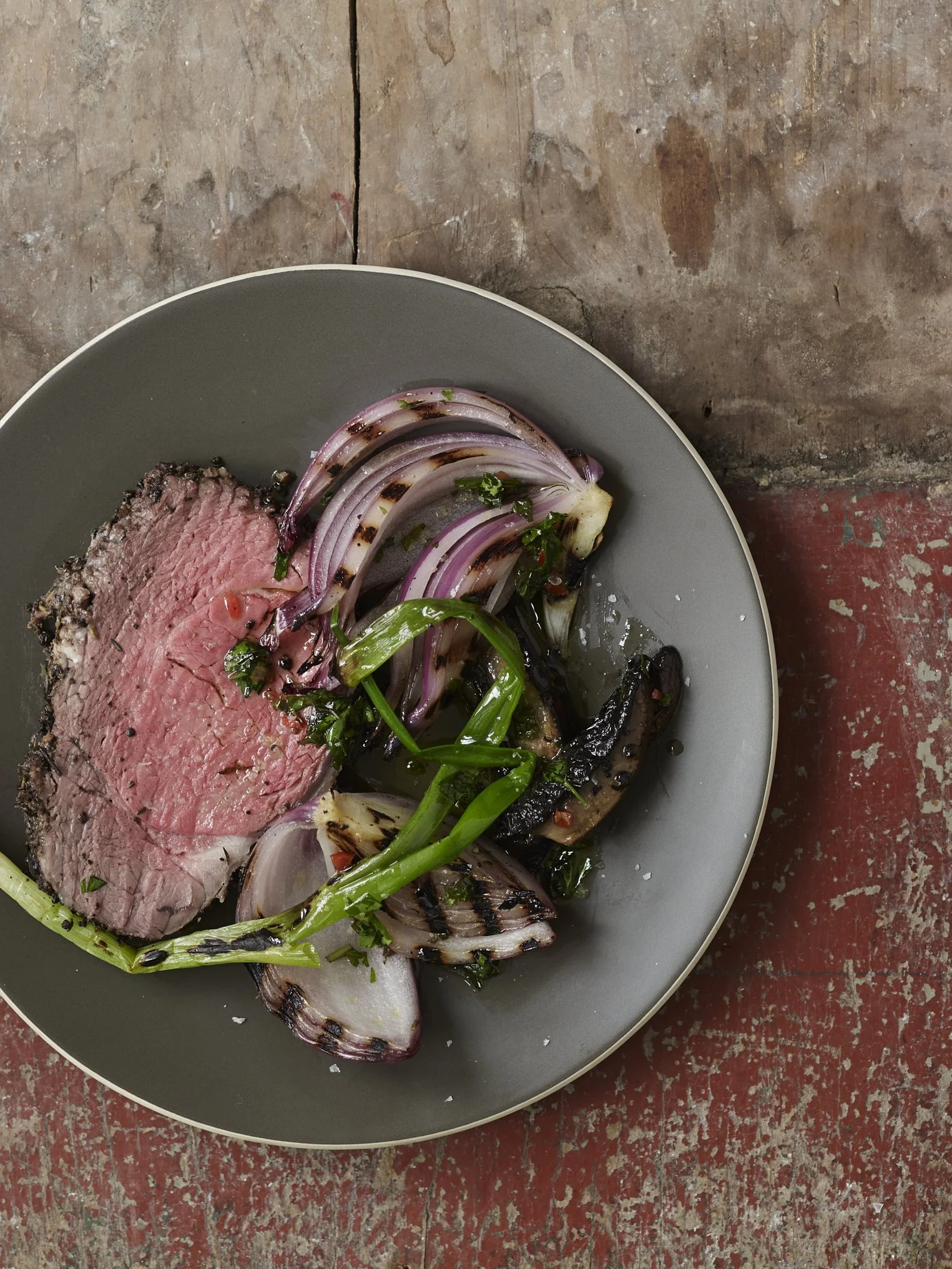 Grilled beef and onions in a gray serving plate.