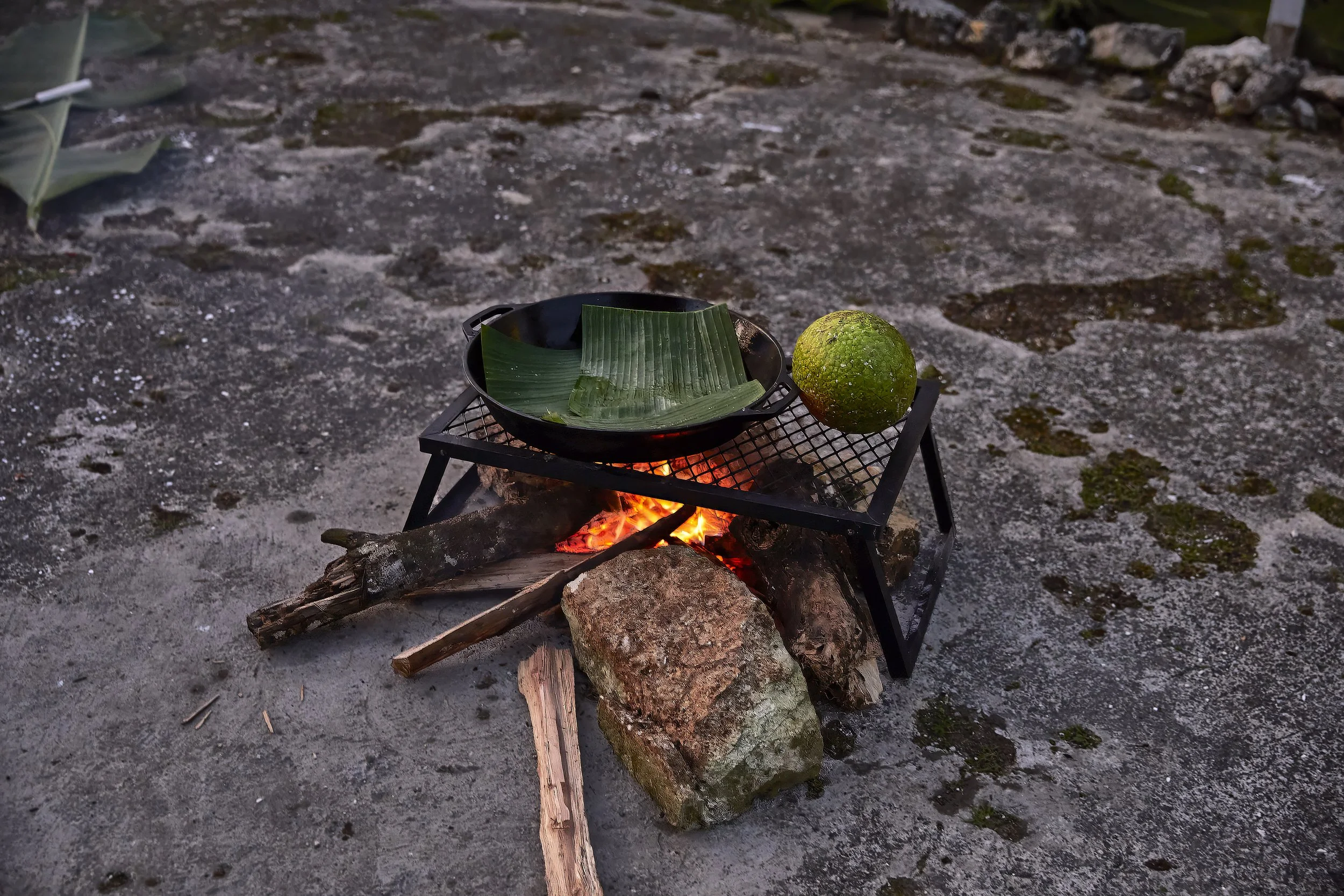 An outdoor stove with a fire below.