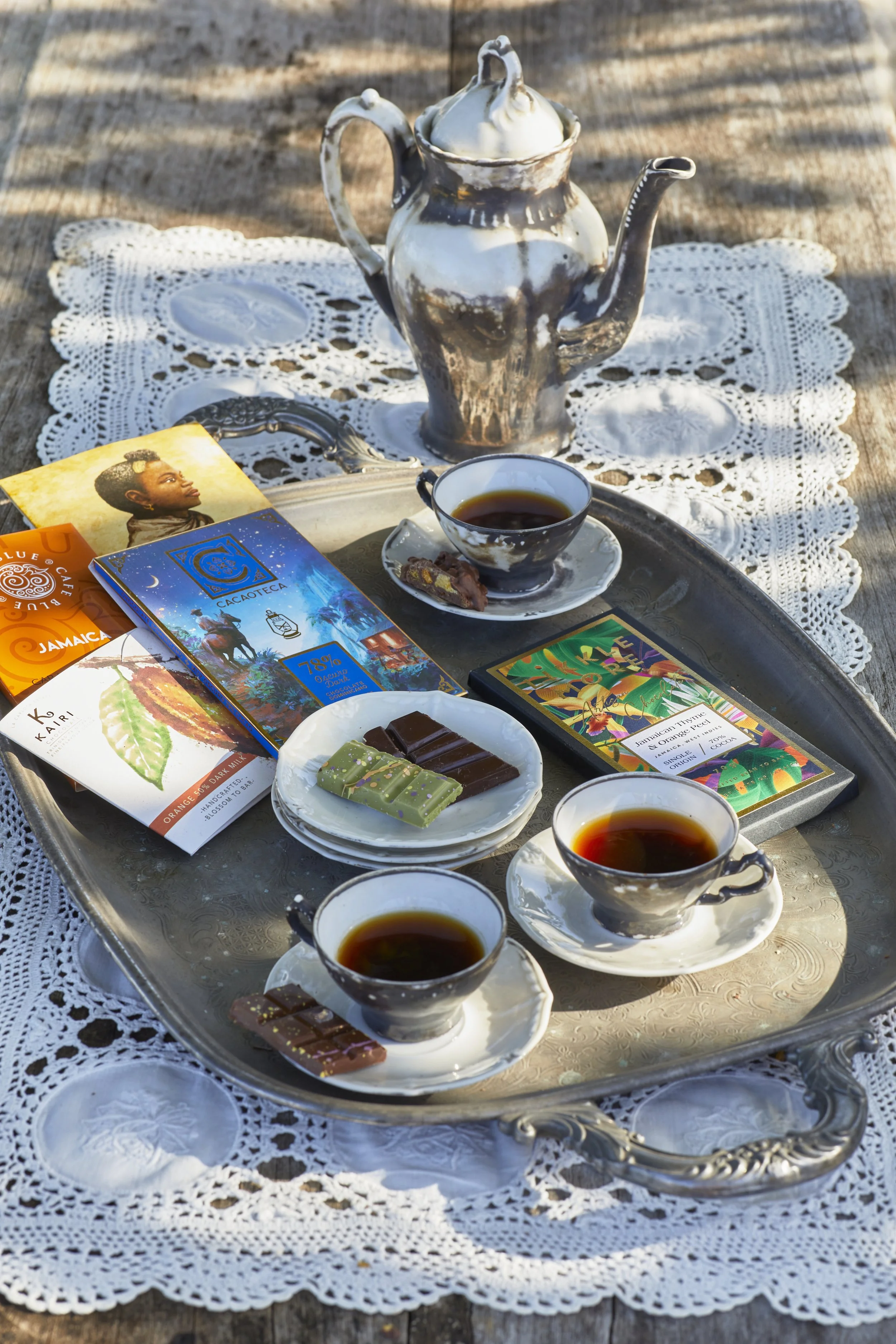 Coffee and chocolate on a metal serving platter.