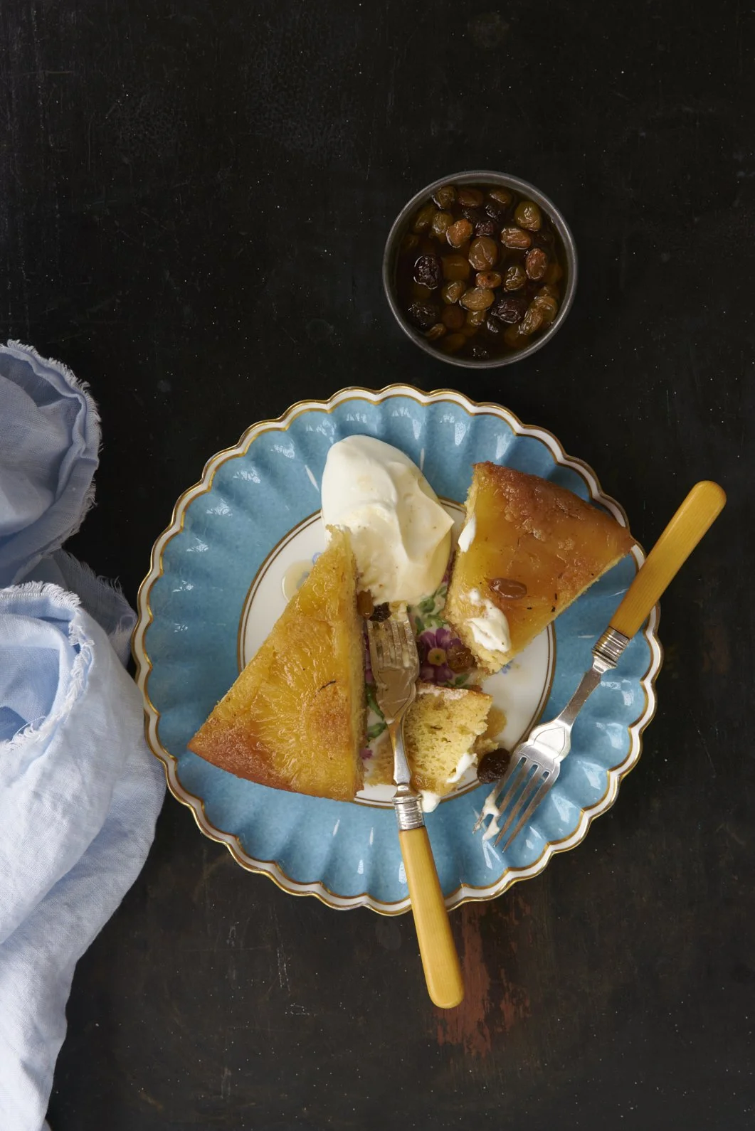 A light blue plate with slices of dessert and cream.