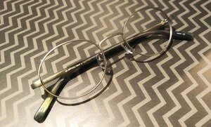 A pair of eyeglasses resting on a black and silver patterned surface