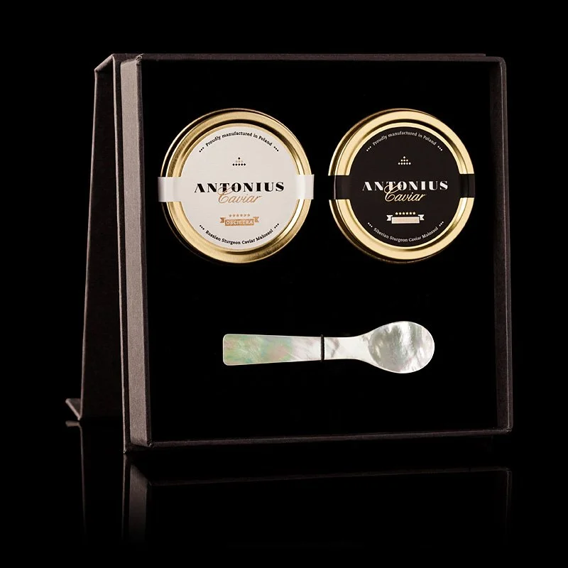Two tins of Antonus caviar and a mother-of-pearl spoon in a black gift box.
