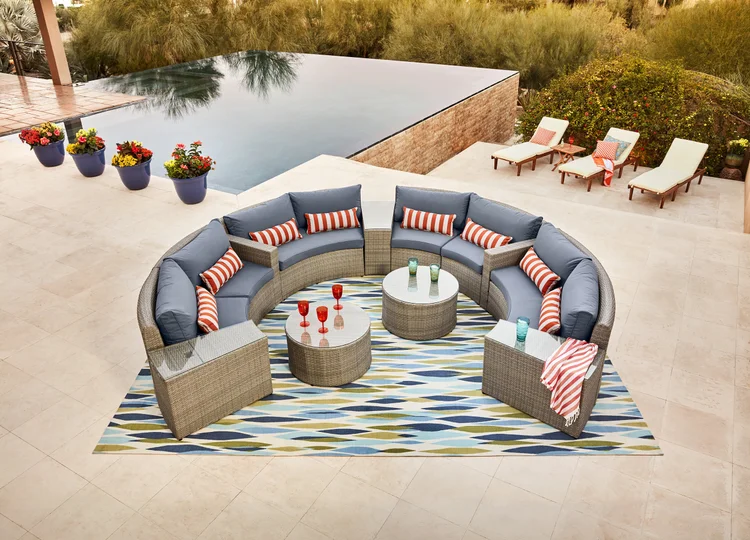 Circular outdoor patio furniture set by a pool after retouching and color grading