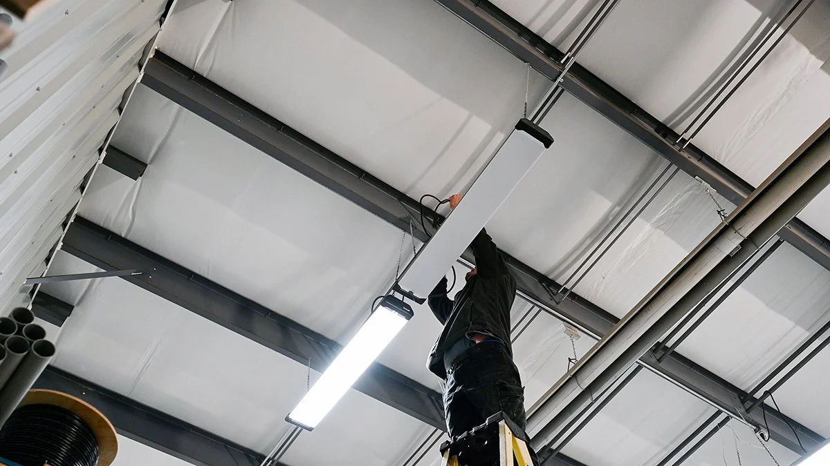 Electrician wiring commercial lighting.