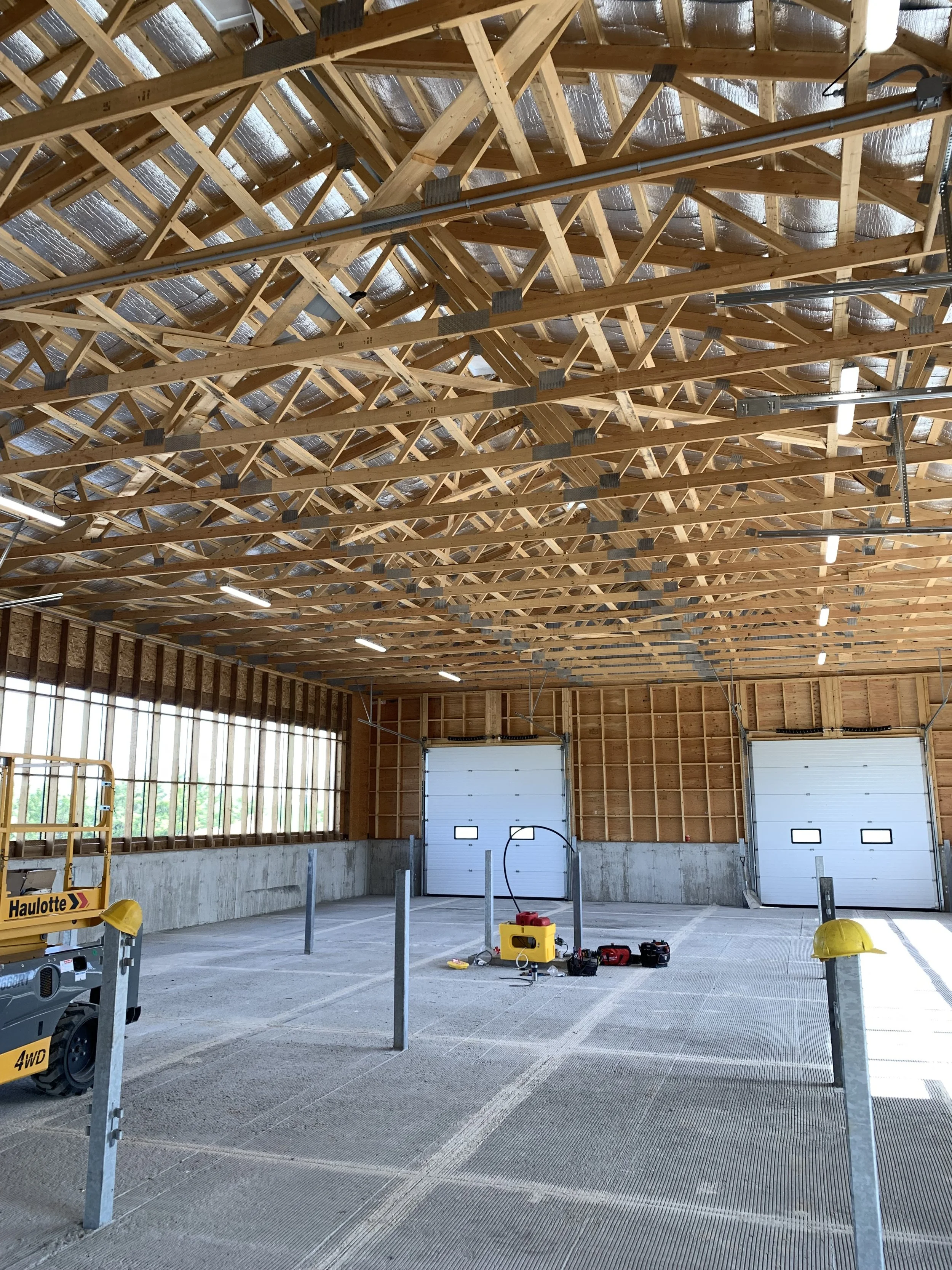 New barn in the construction stage with electrician equipment inside.