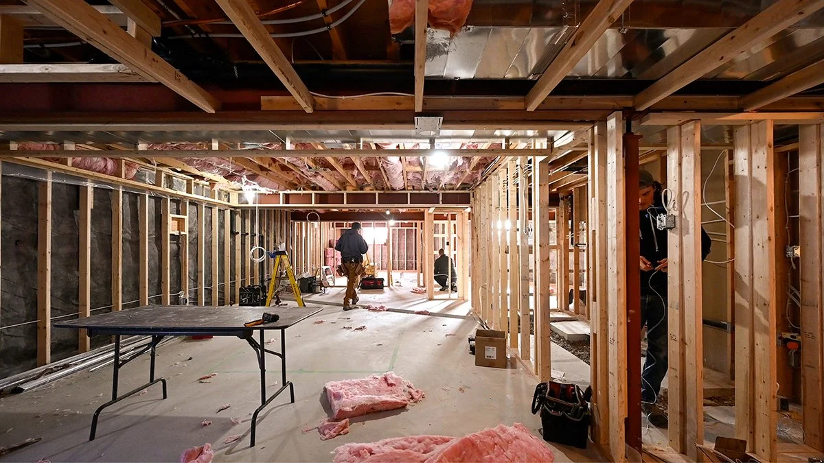 Electrician at work in  a basement being renovated.