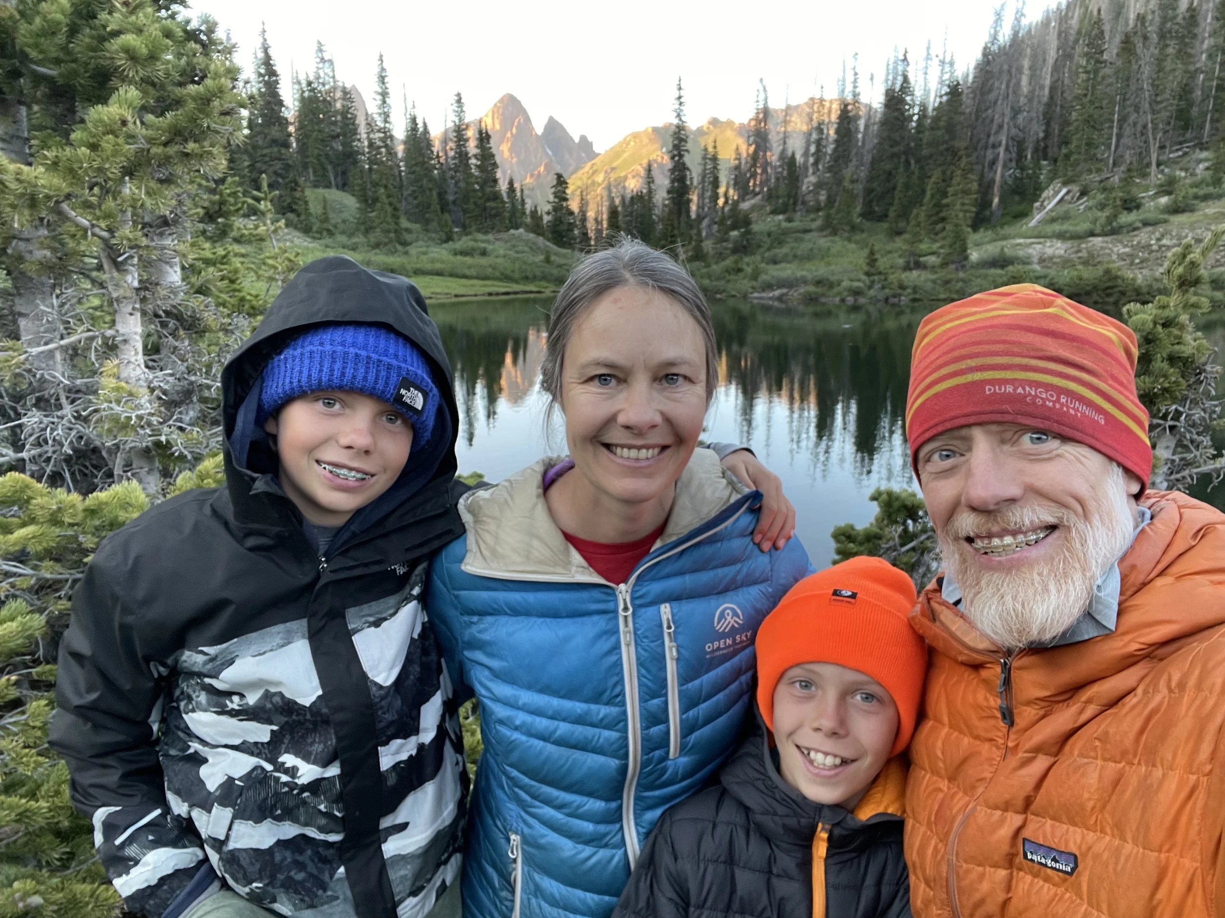 Family with mountains in background reflecting on the serene and majestic Emerald lake