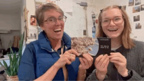 Brenna and Vanessa showing off the final draft of the 2026 postcard calendar.