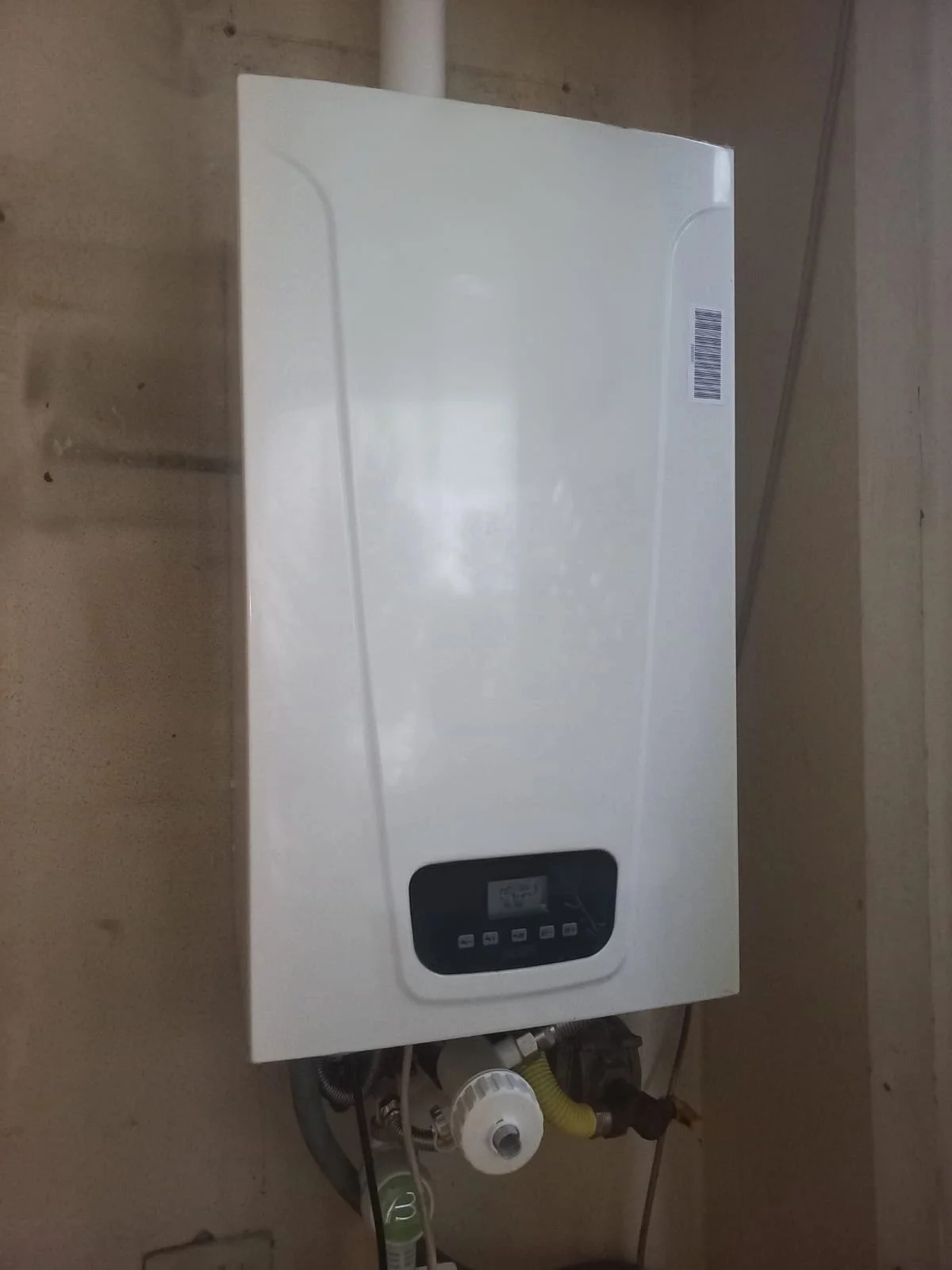 Scatola del boiler a muro con pannello di controllo digitale e tubature sottostanti.