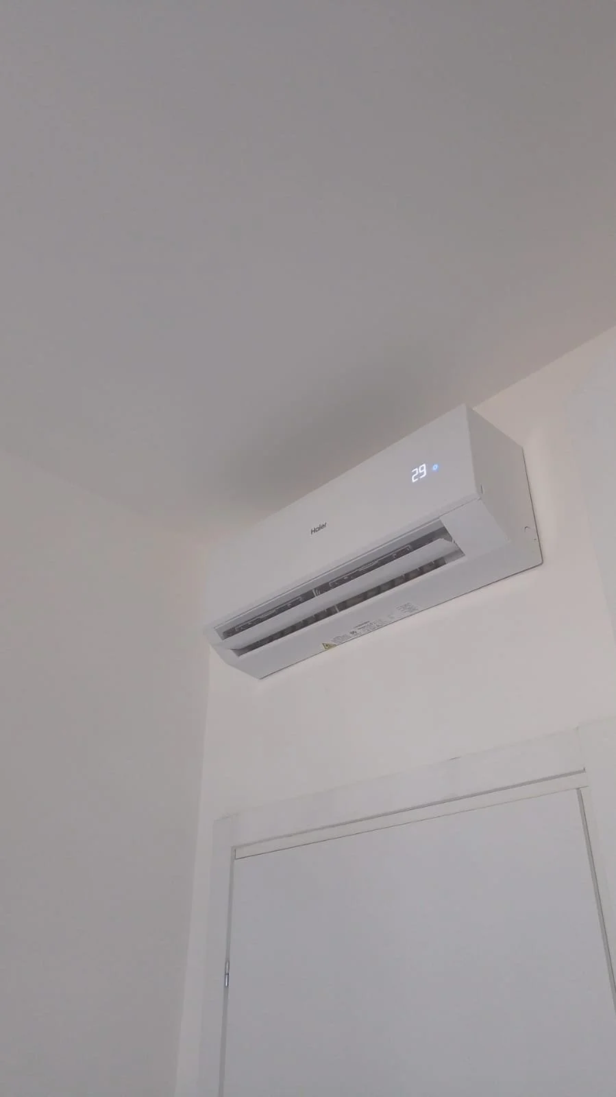 Climatizzatore Daikin installato sul soffitto in una stanza, con display che mostra la temperatura di 29 gradi Celsius.
