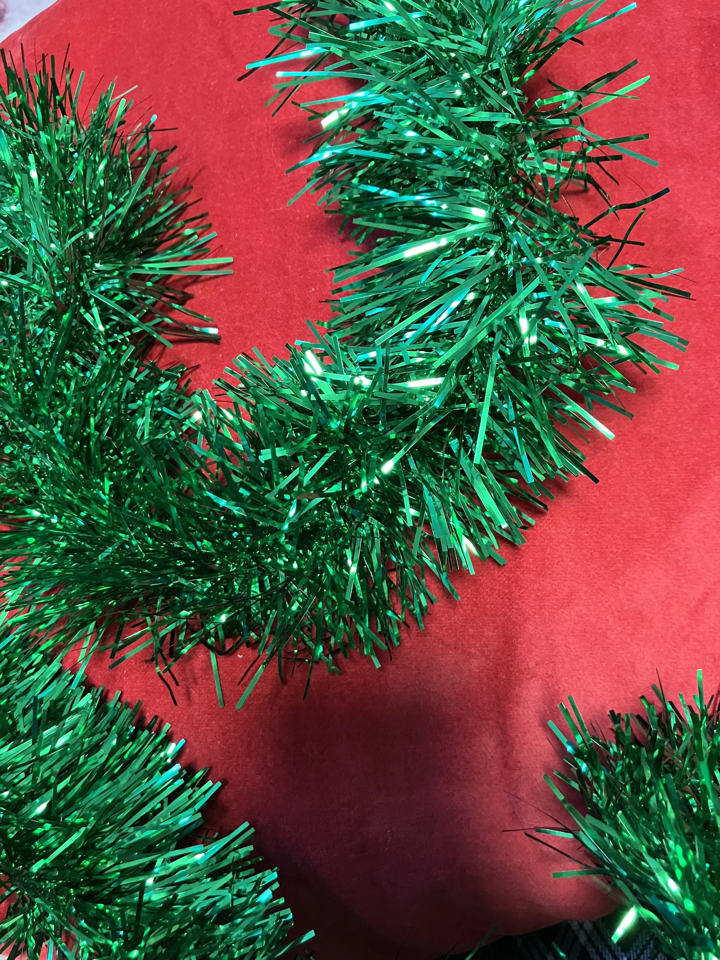 Green tinsel garland on a red background.