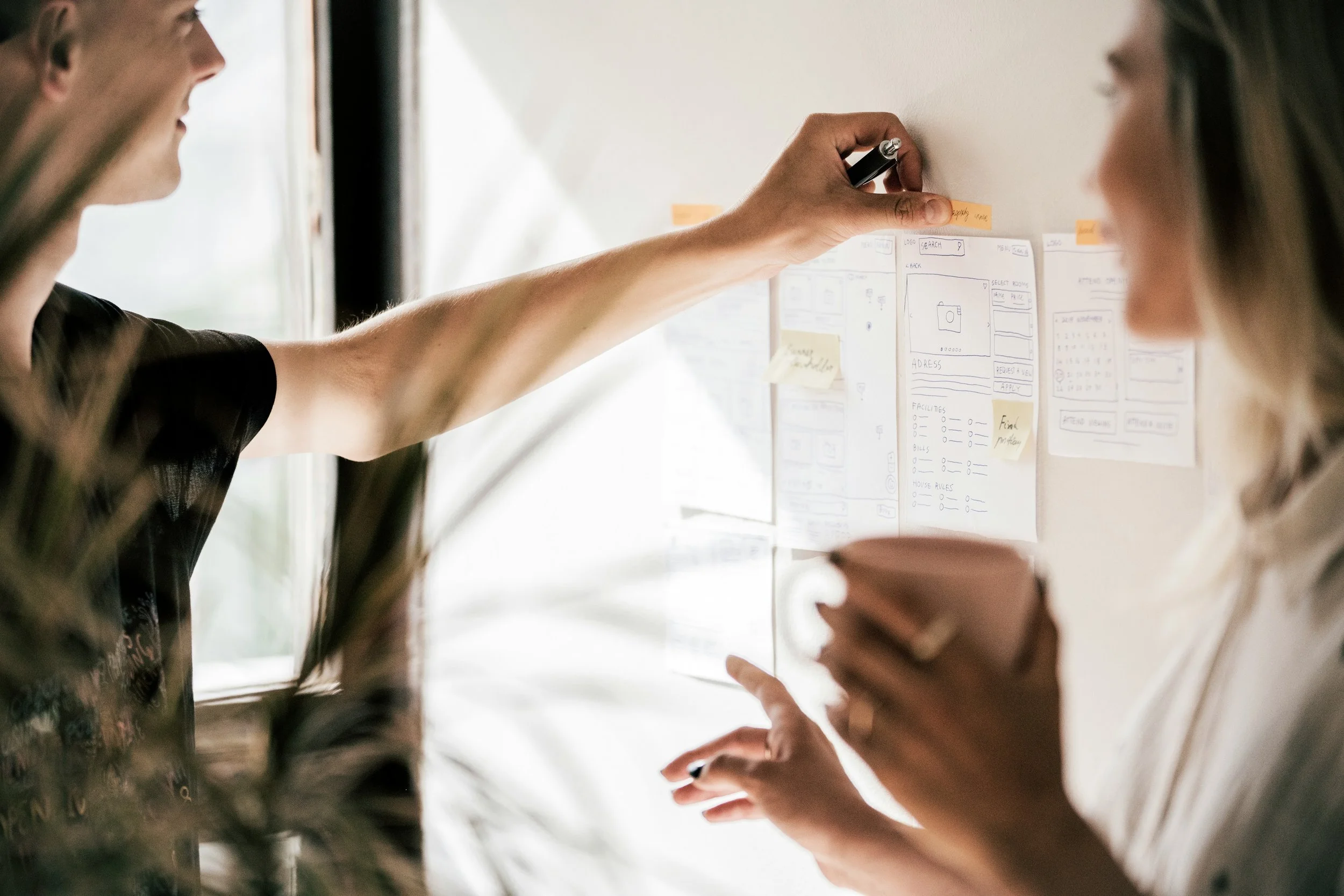 Two people collaborating in an office, looking at and discussing operational optimization opportunities.