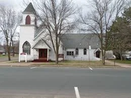 white church with belltower and red doors