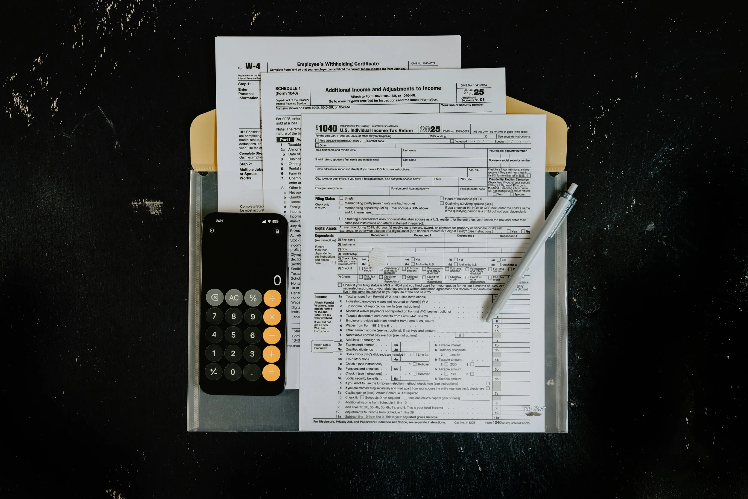 US income tax forms on a desk with calculator and pen