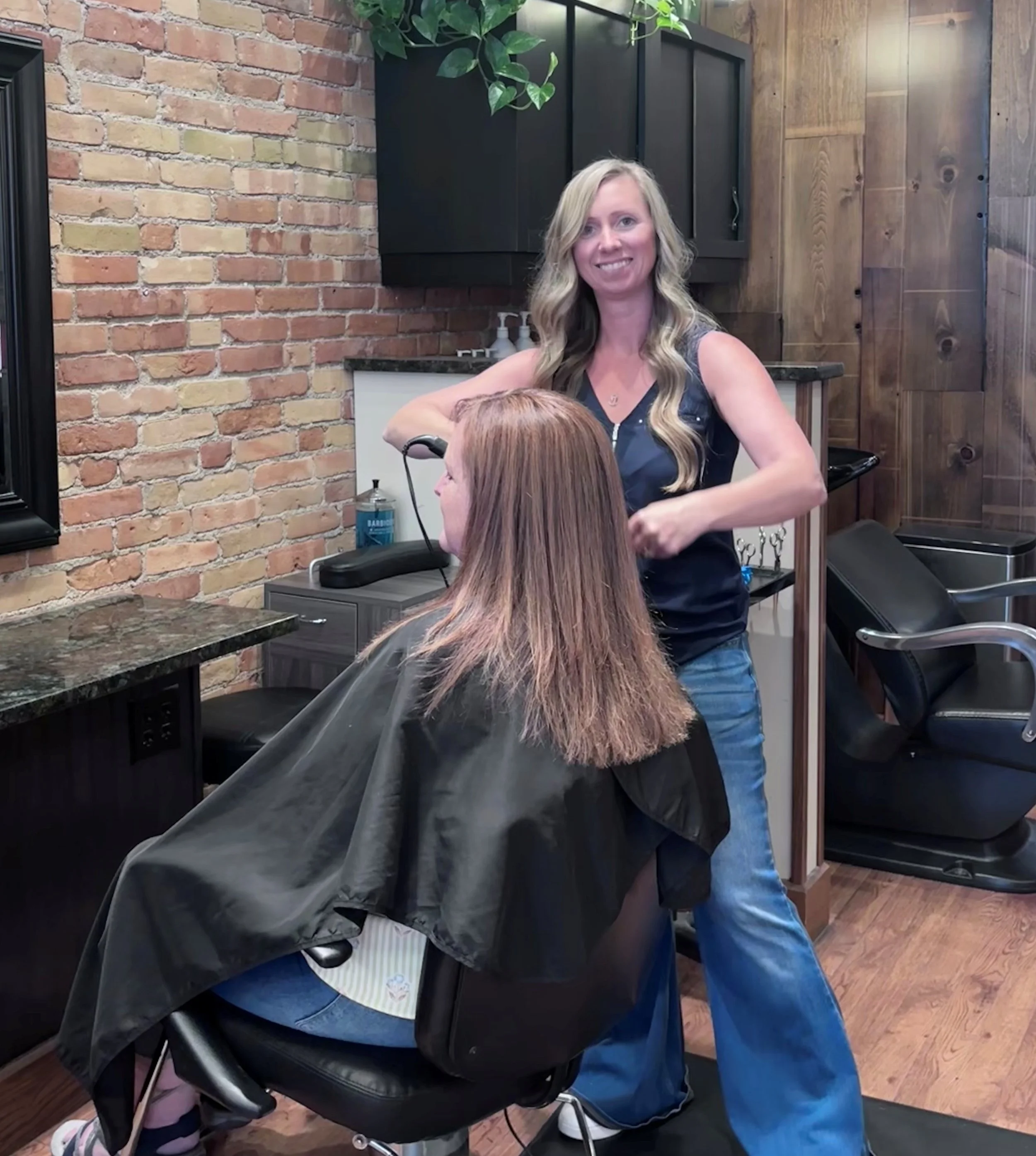 Chelsea Michigan hair stylist cutting a woman's hair in a salon.