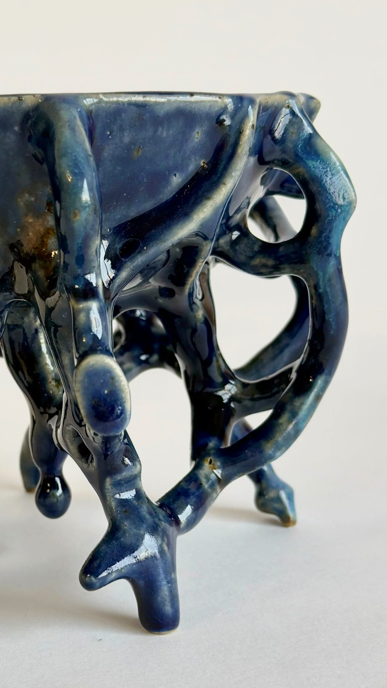 Close-up detail of the surface and glaze on a hand-built blue stoneware bowl.