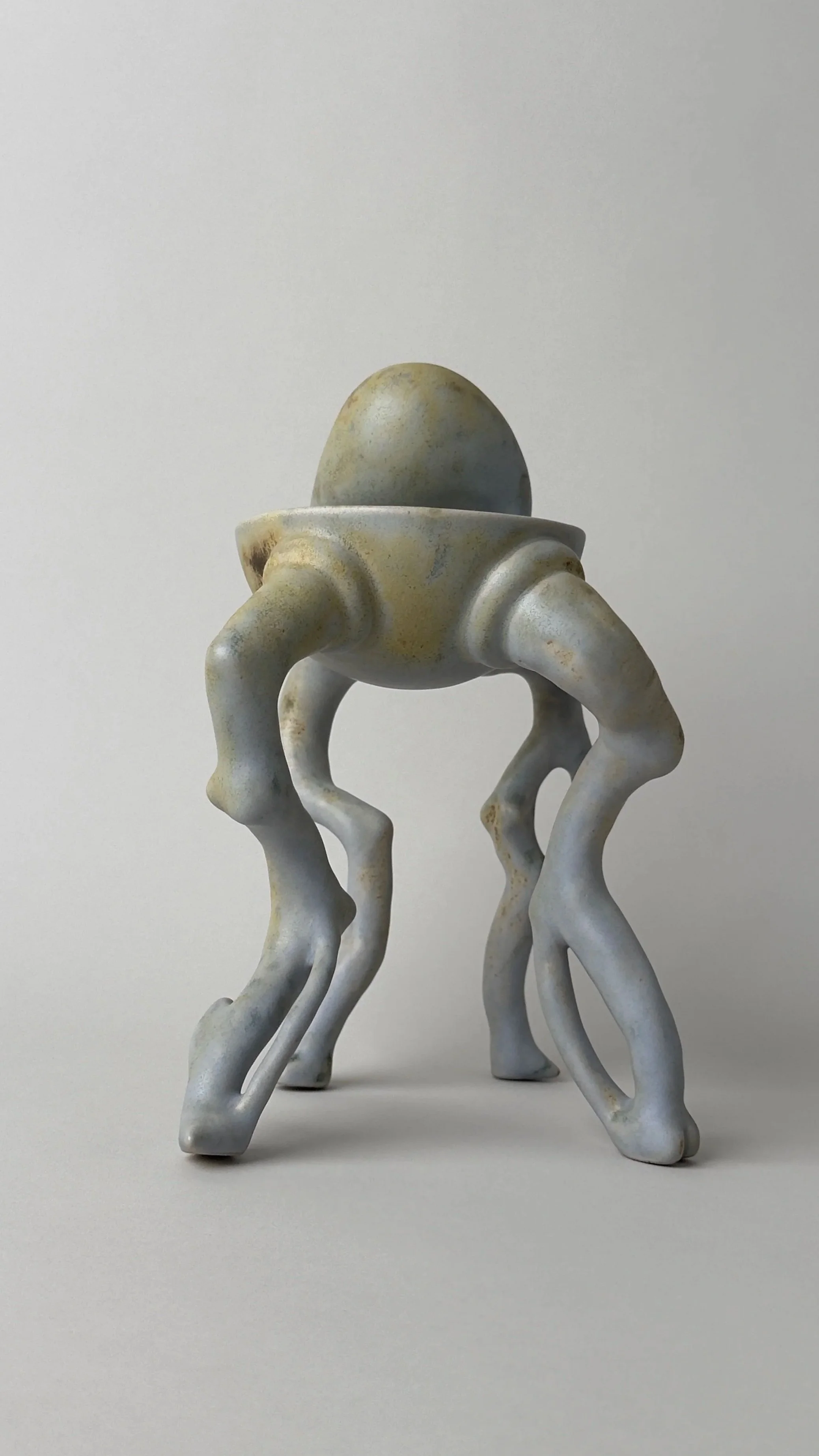 Crisálida Bowl, sculptural ceramic bowl with four organic legs and a rounded egg-like form rising from the back.