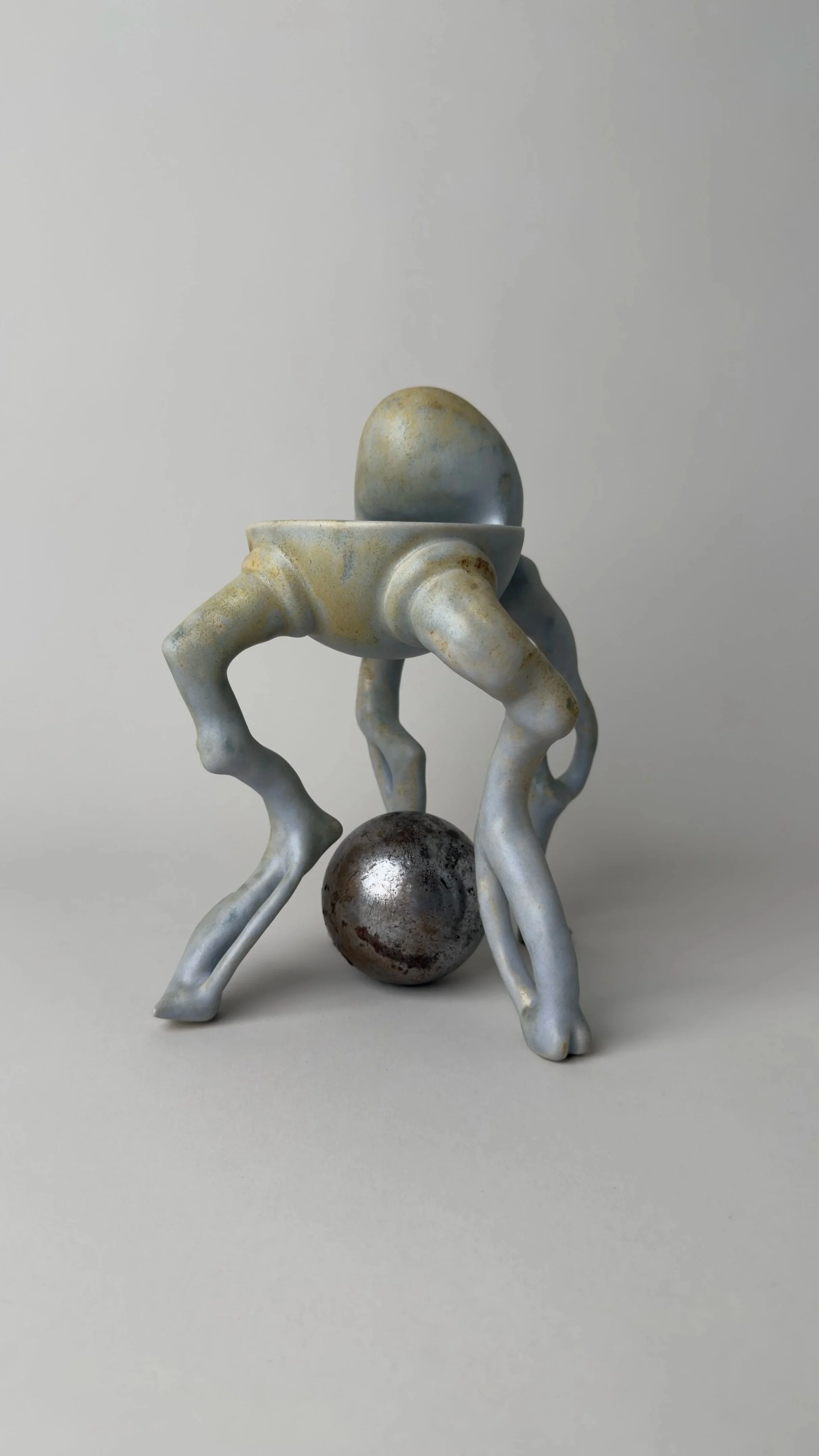 Crisálida Bowl, sculptural ceramic bowl with four organic legs and a rounded egg-like form rising from the back. With a metallic sphere in between its legs.