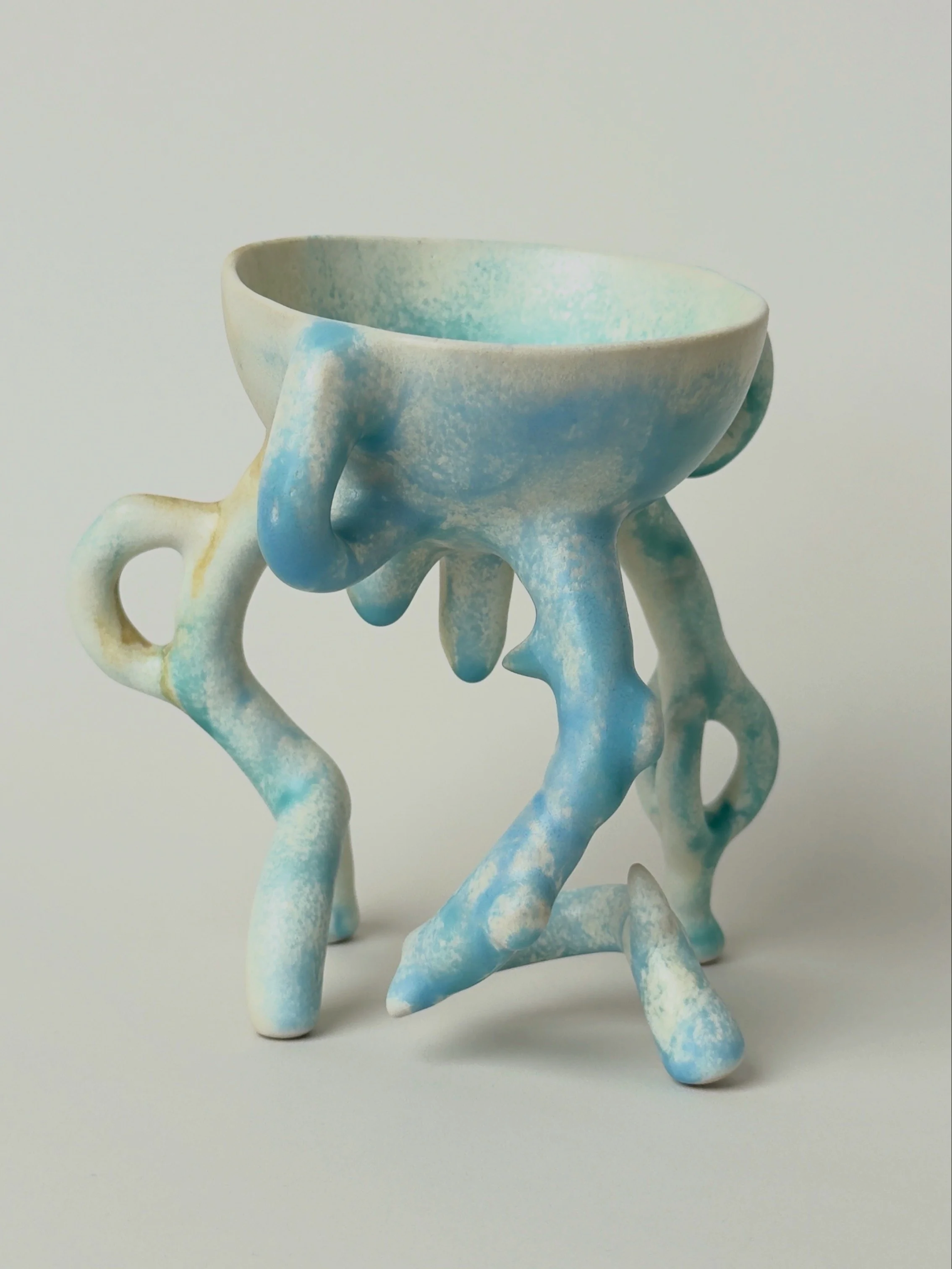 Hope Bowl, sculptural ceramic bowl with an organic four-legged structure and a soft blue, white and brown glaze.