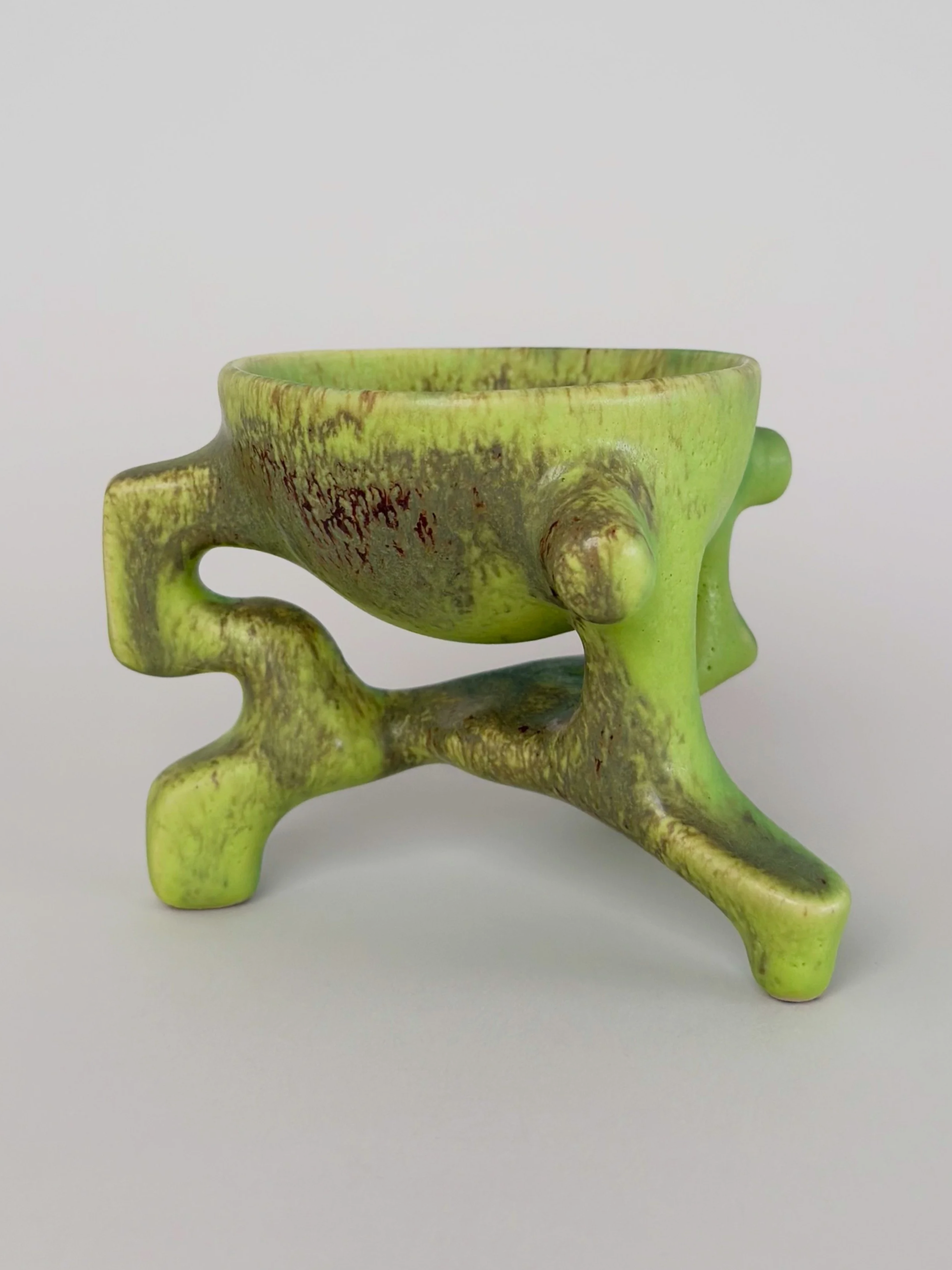 Poisonous Frog Cup, sculptural ceramic cup with a green and yellow glaze and an organic four-legged base.