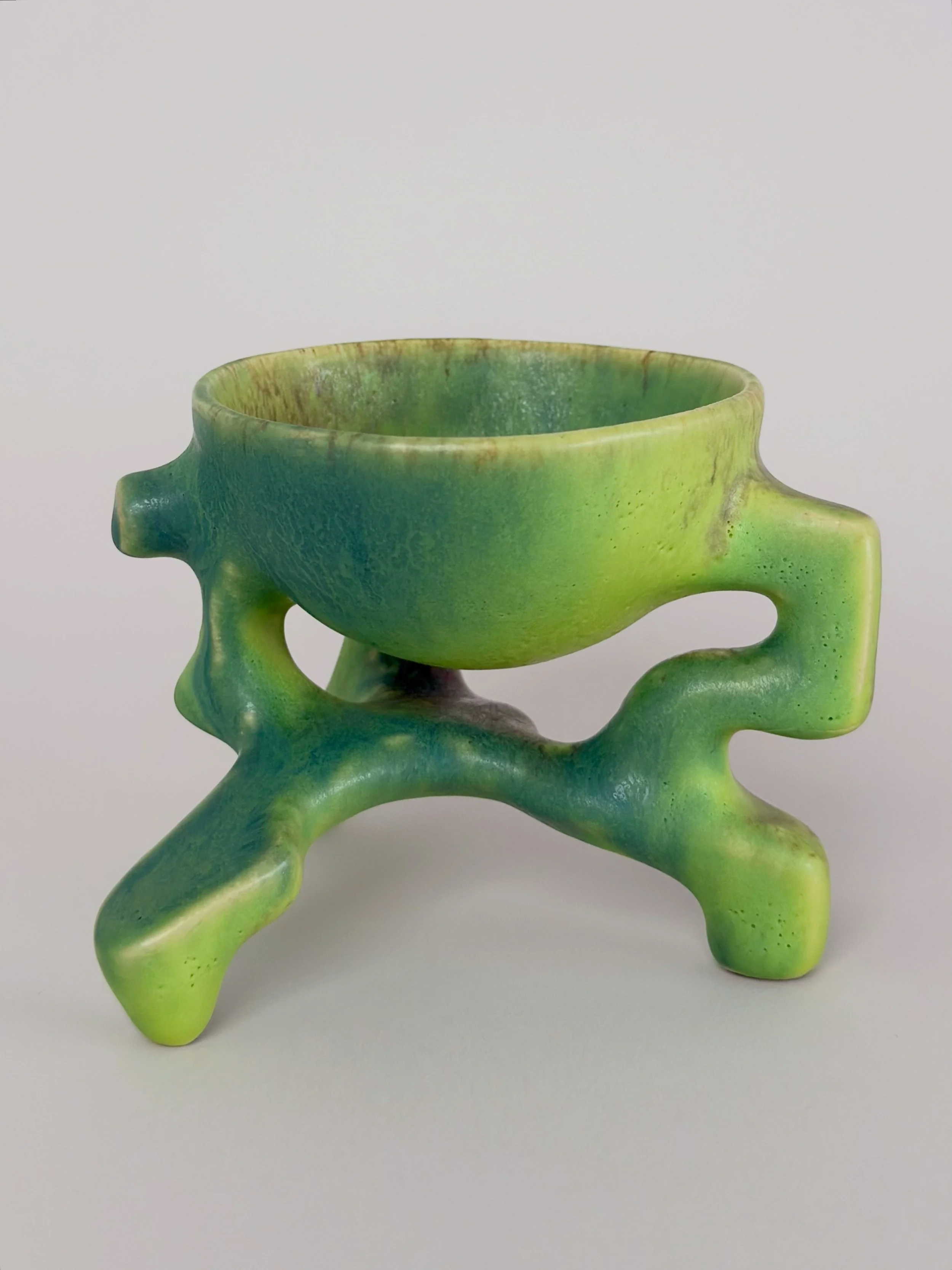 Poisonous Frog Cup, sculptural ceramic cup with a green and yellow glaze and an organic four-legged base.