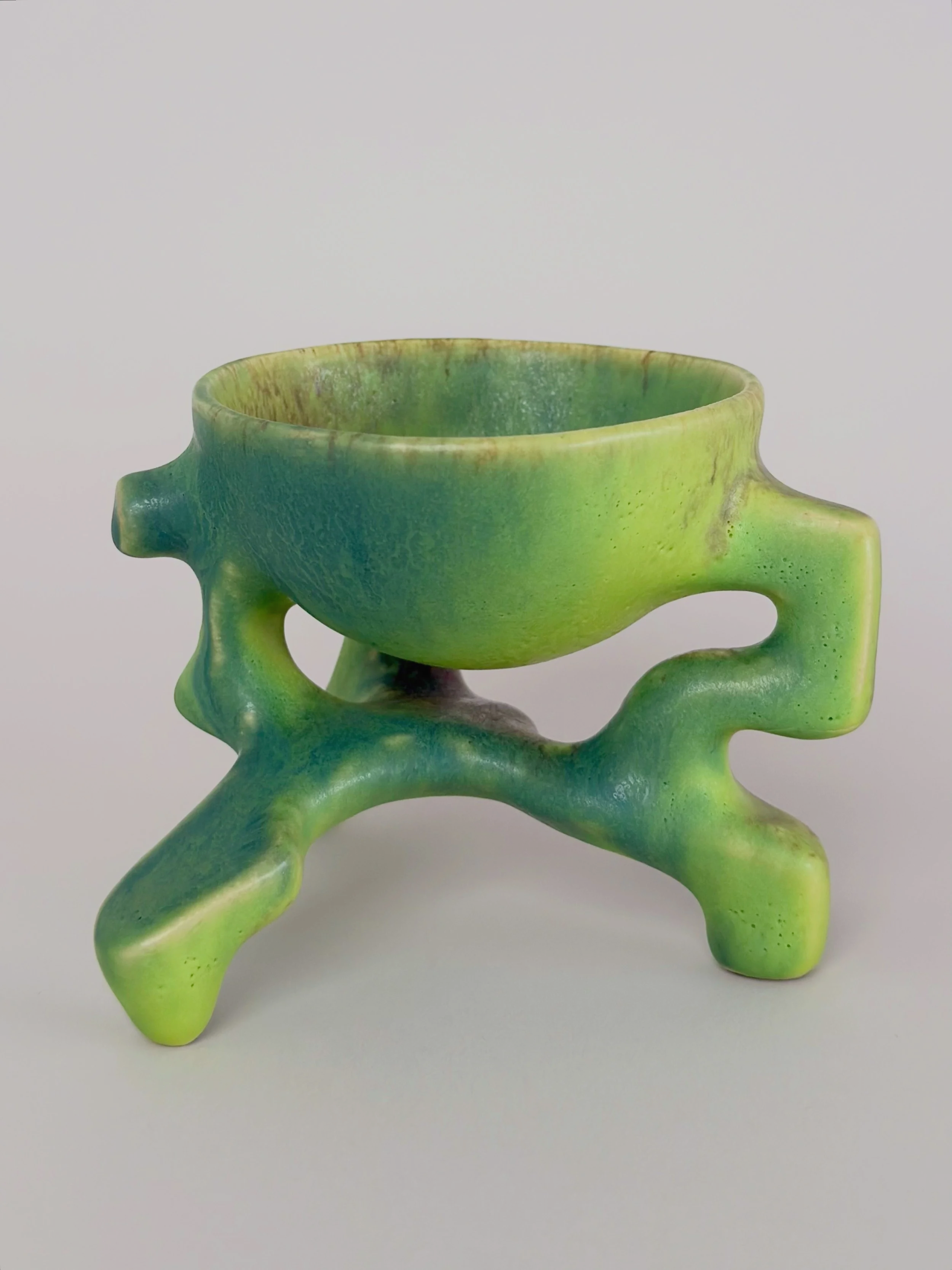 Poisonous Frog Cup, sculptural ceramic cup with a green and yellow glaze and an organic four-legged base.