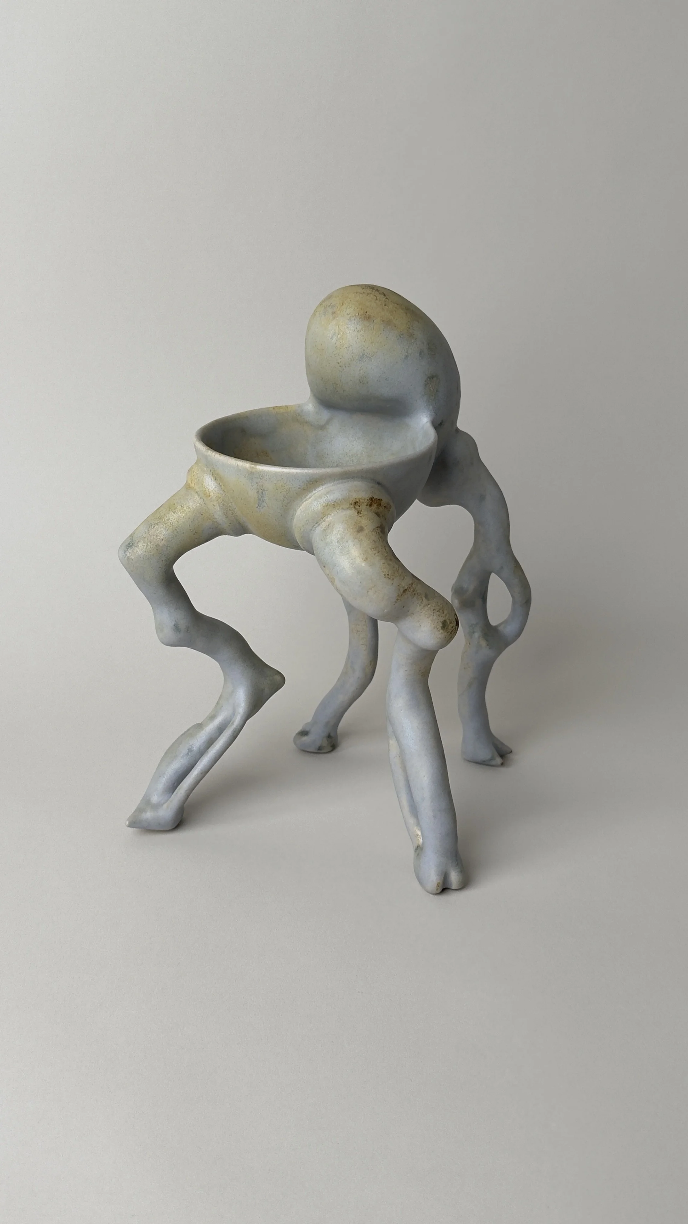 Crisálida Bowl, sculptural ceramic bowl with four organic legs and a rounded egg-like form rising from the back.