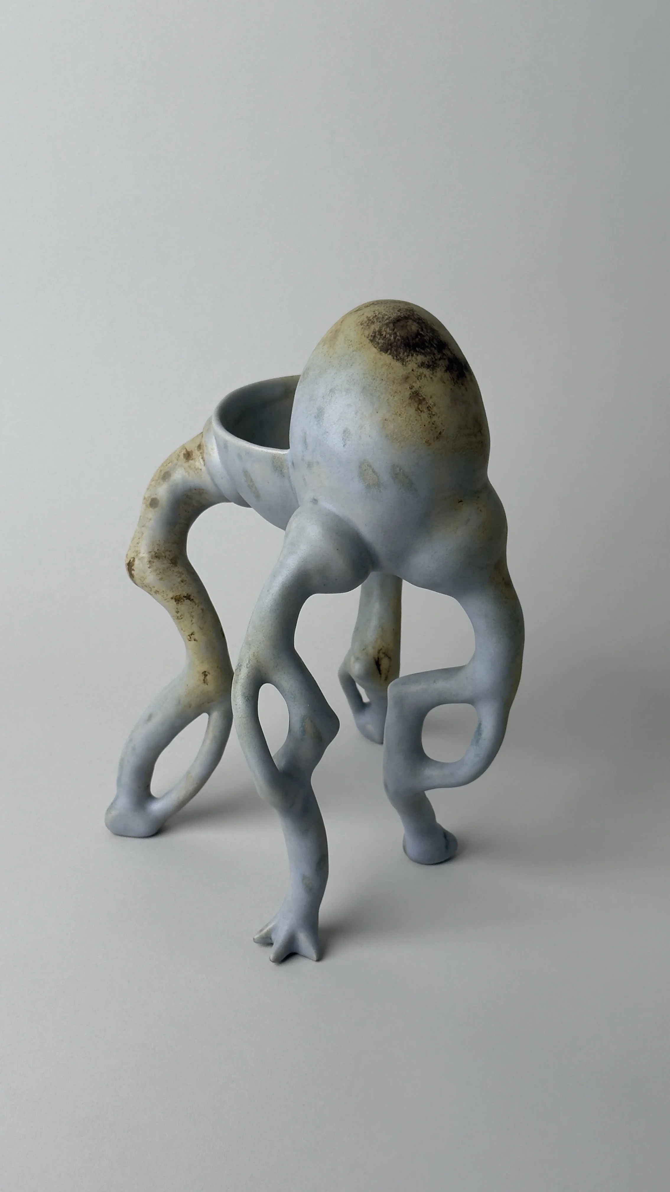 Crisálida Bowl, sculptural ceramic bowl with four organic legs and a rounded egg-like form rising from the back.