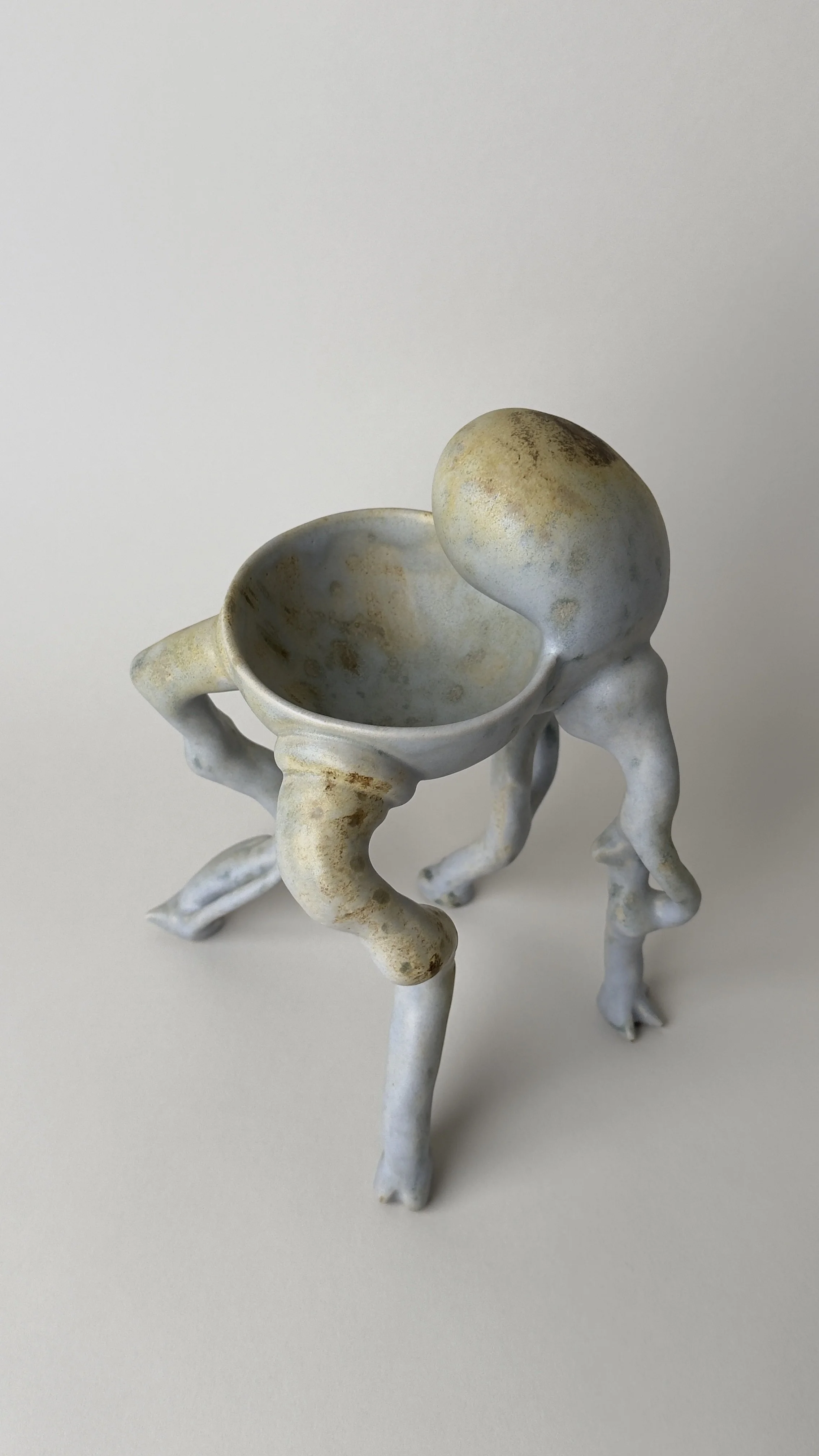 Crisálida Bowl, sculptural ceramic bowl with four organic legs and a rounded egg-like form rising from the back.