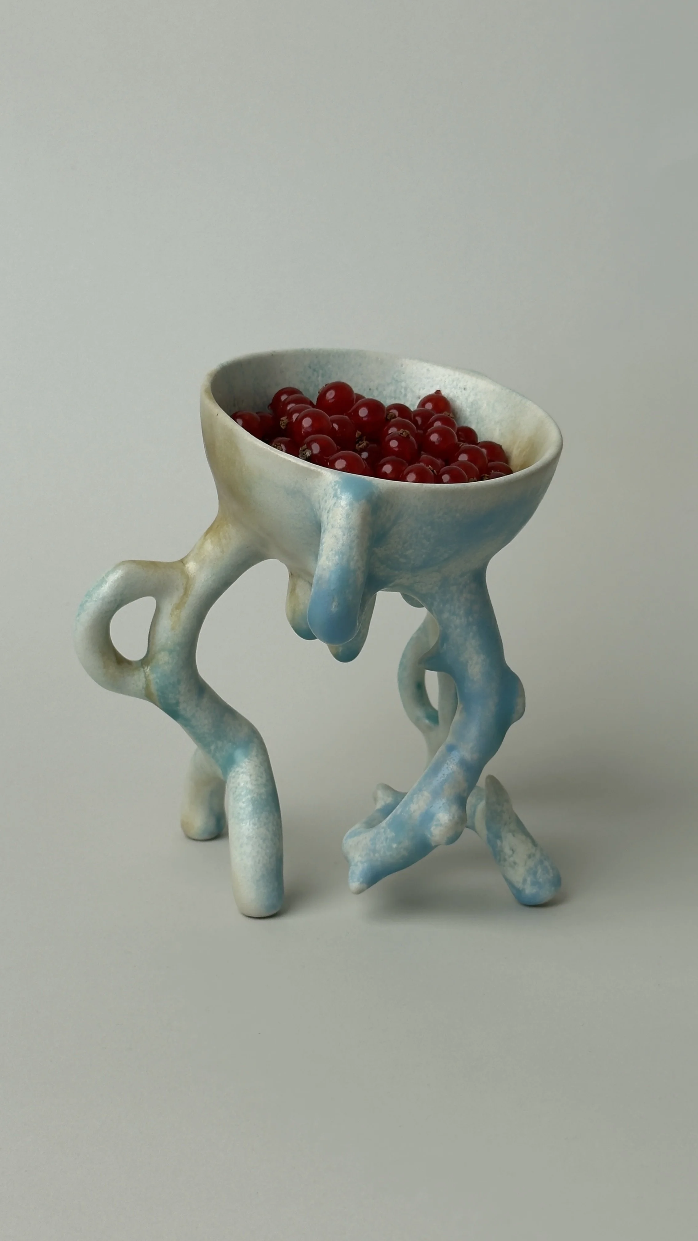 Hope Bowl, sculptural ceramic bowl with an organic four-legged structure and a soft blue, white and brown glaze.