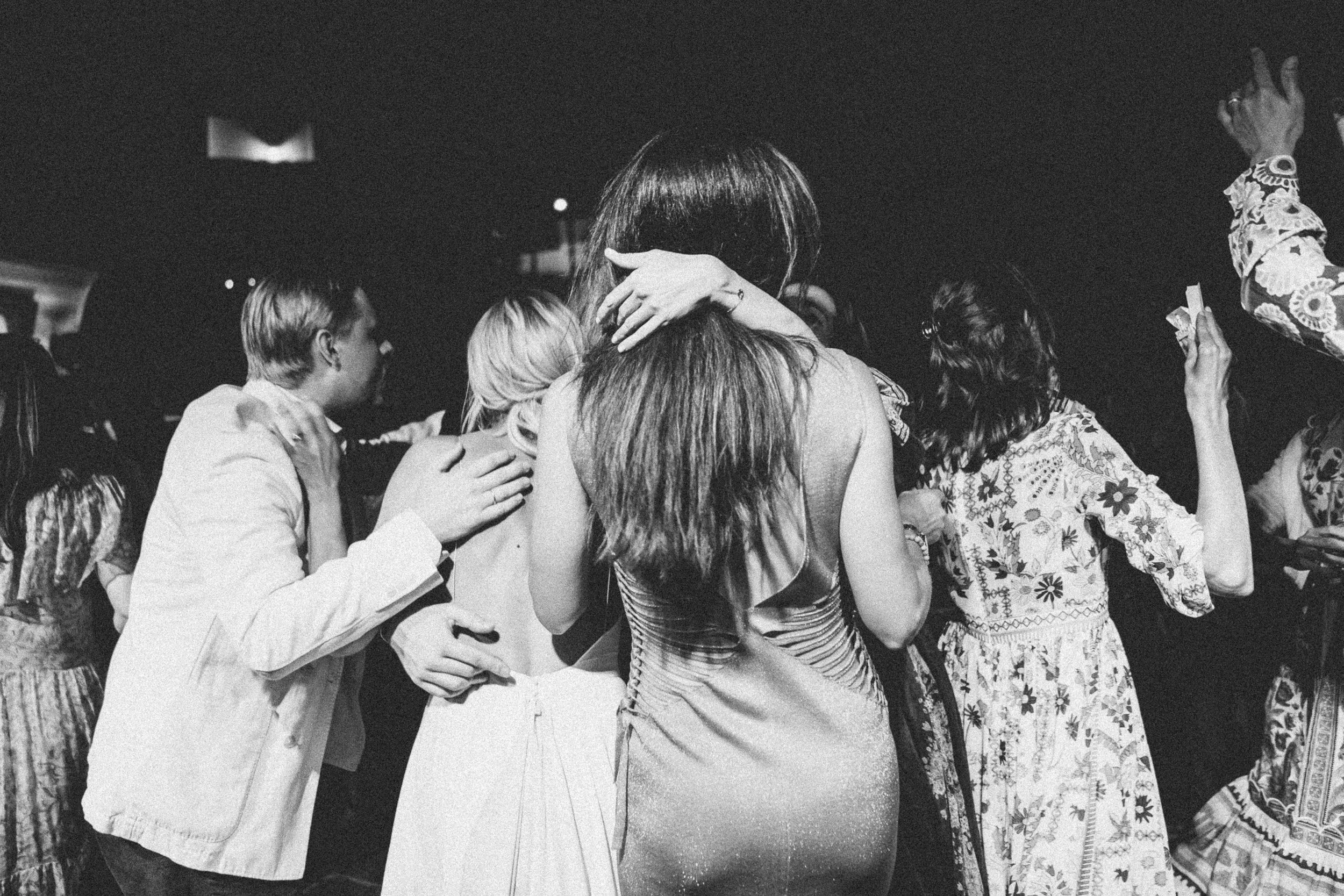Group of people hugging and embracing at a social event.