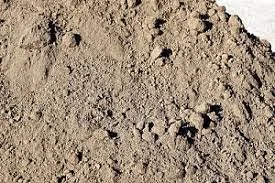 Close-up of dirt or soil with small pebbles and uneven surface.