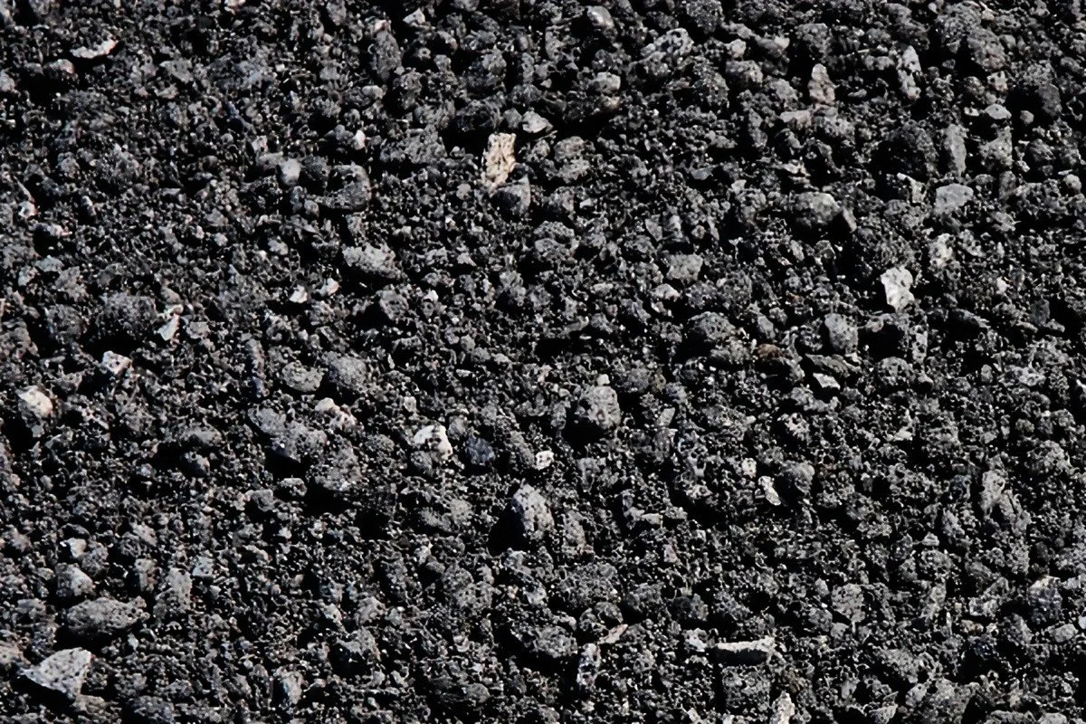 Close-up of black gravel or crushed rock surface.