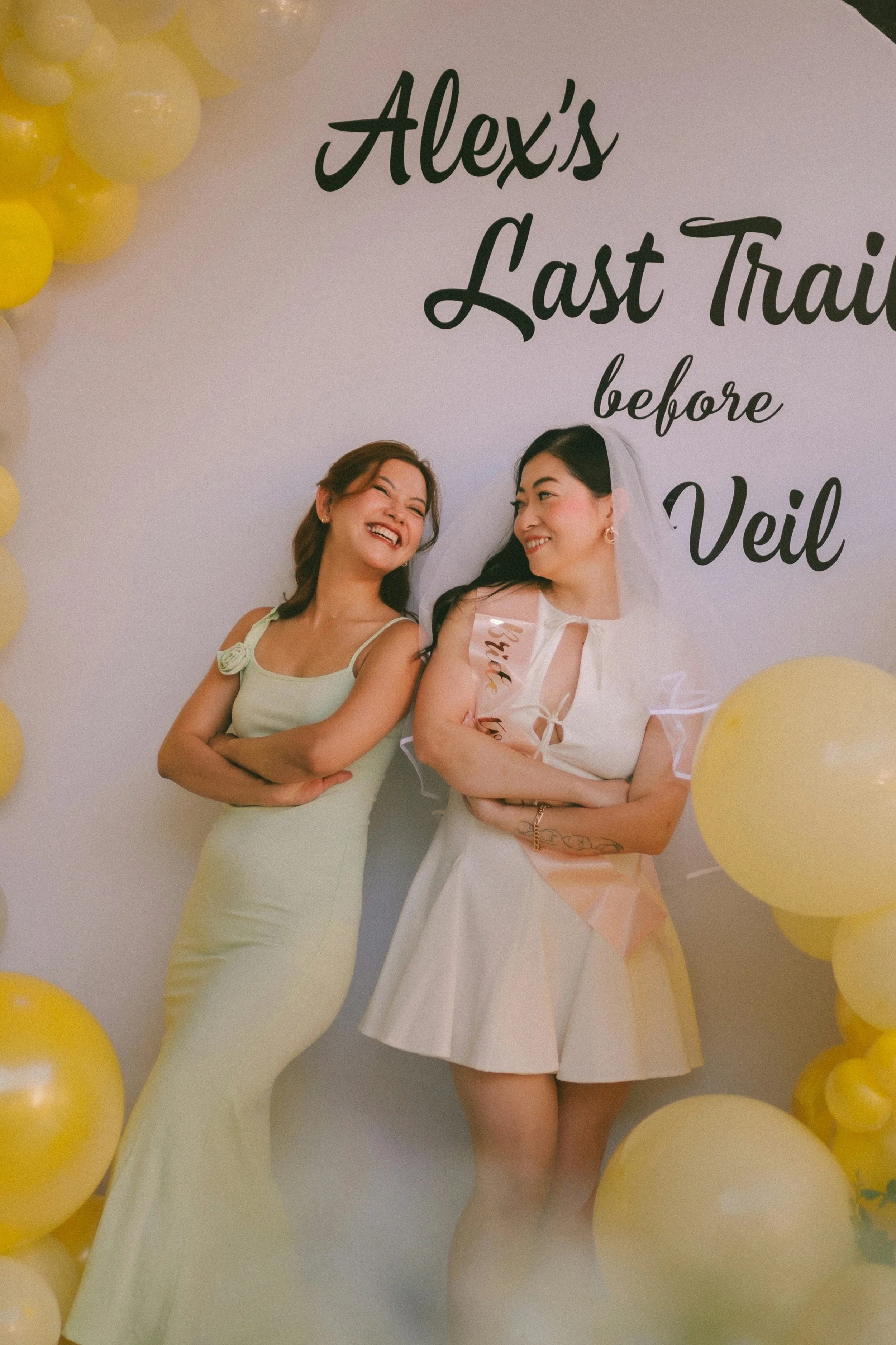 Child playing with large bubbles outdoors, wearing a colorful jacket, with other children in the background.