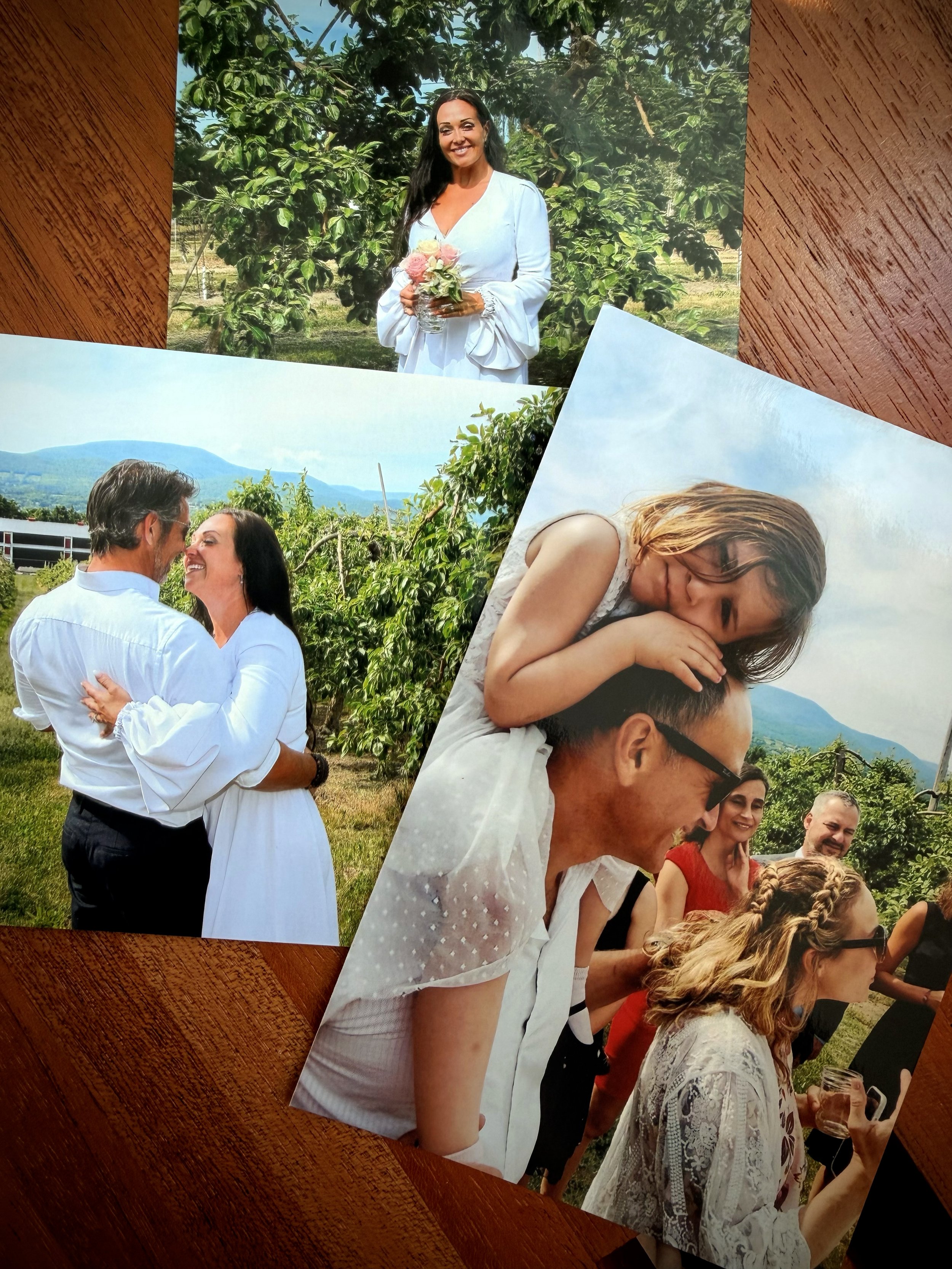 Lumica printed photos disposable camera film retro analog app simulation instant 35mm grain. couple at a wedding, posing outdoors in a green scenic area with mountains in the background.